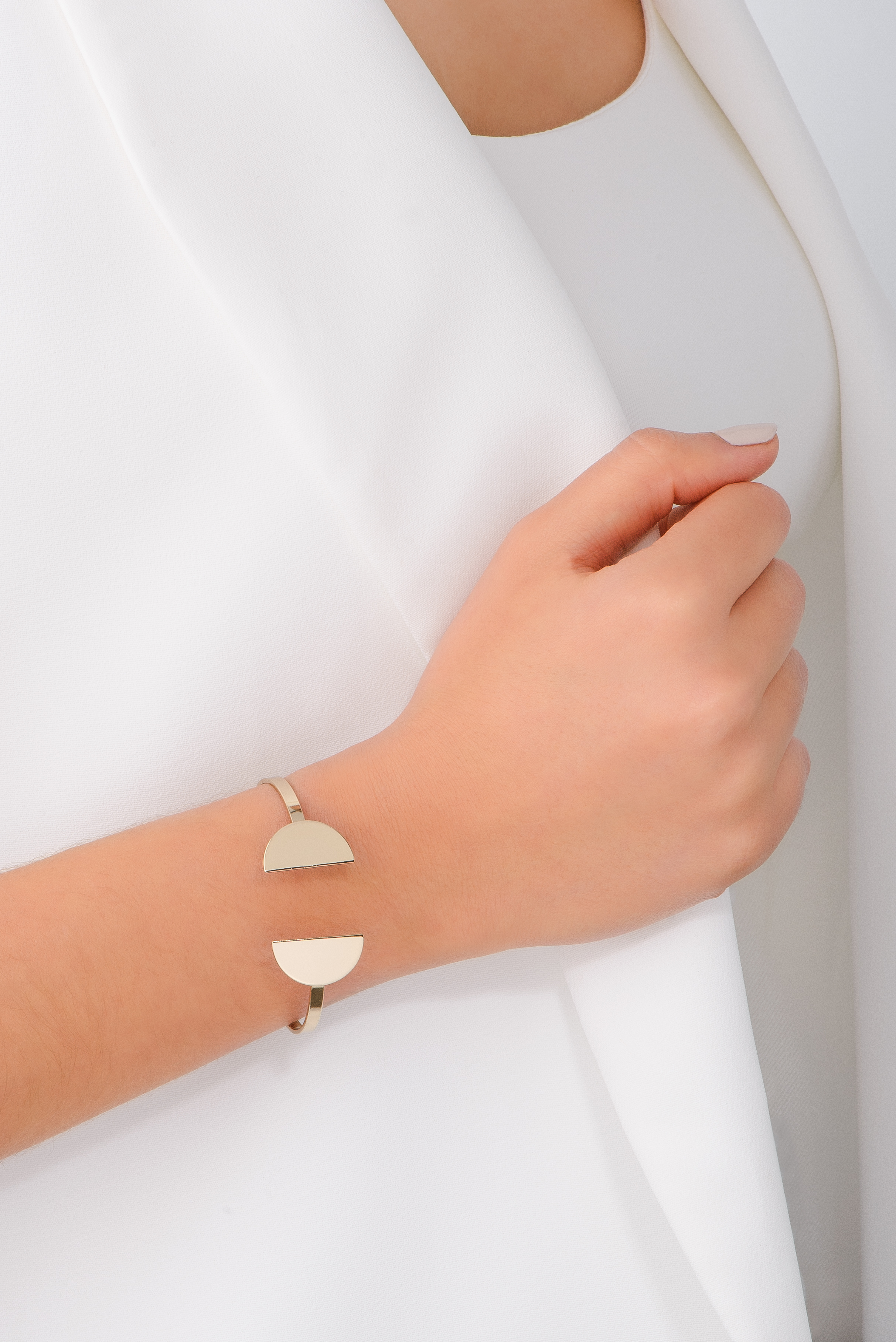 Brazalete ajustable con diseño innovador, con dos semicírculos en baño de oro, que añaden un estilo contemporáneo.
-        Pulsera
-        Medida ajustable
-        Baño de Oro 18k
