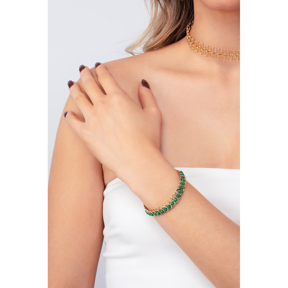 Un diseño de cadena entretejida se mezcla en esta pulsera en baño de oro, con abalorios en tono verde esmeralda. Combínala con tus aretes.
-        Pulsera
-        Medida única
-        Baño de Oro 18k
-        Abalorios en tono verde esmeralda
