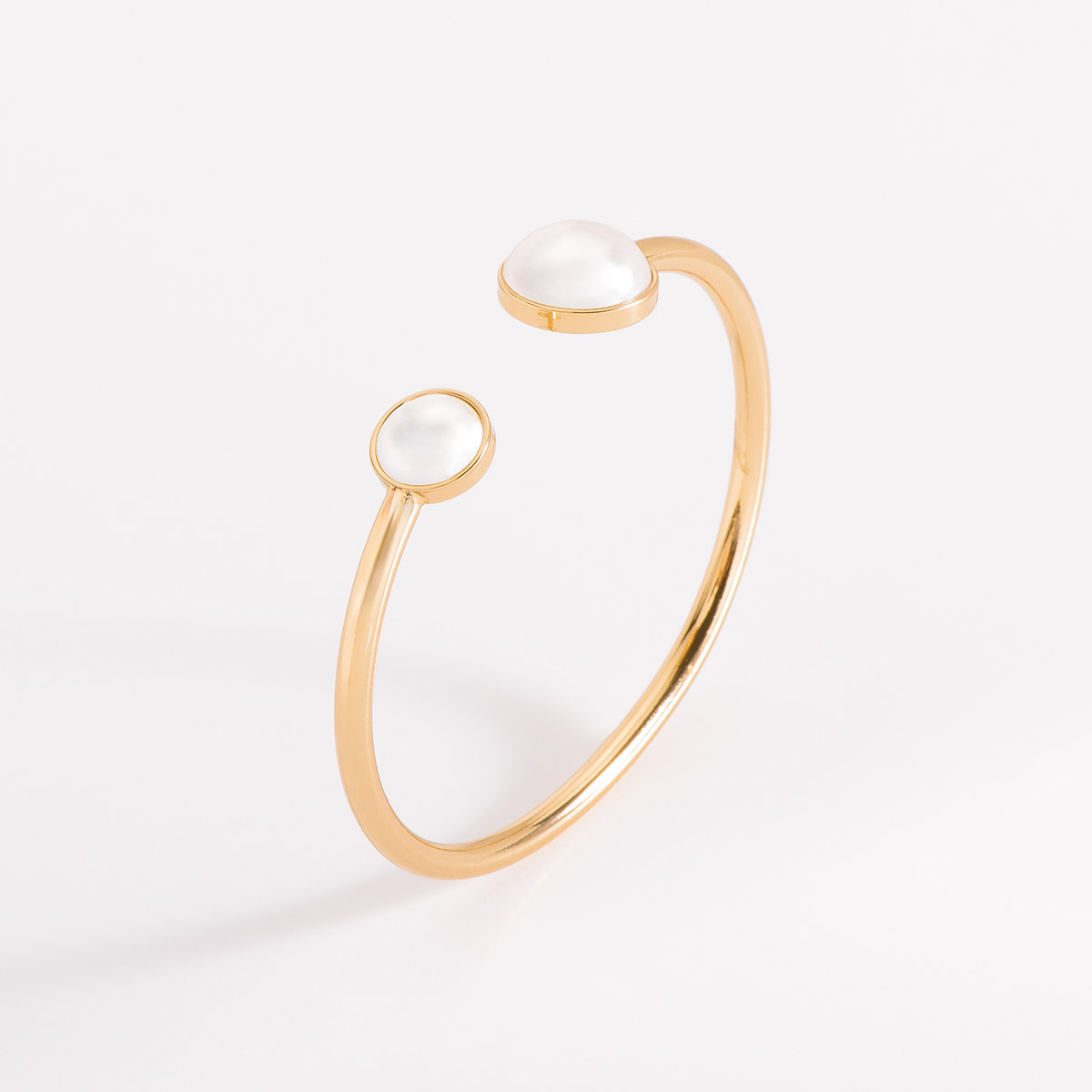 Pulsera con diseño minimalista en baño de oro; se destaca por sus dos extremos adornados con perlas cultivadas de diferentes tamaños.
-        Pulsera
-        Medida ajustable
-        Baño de Oro 18k
-        Perlas en tono cream
