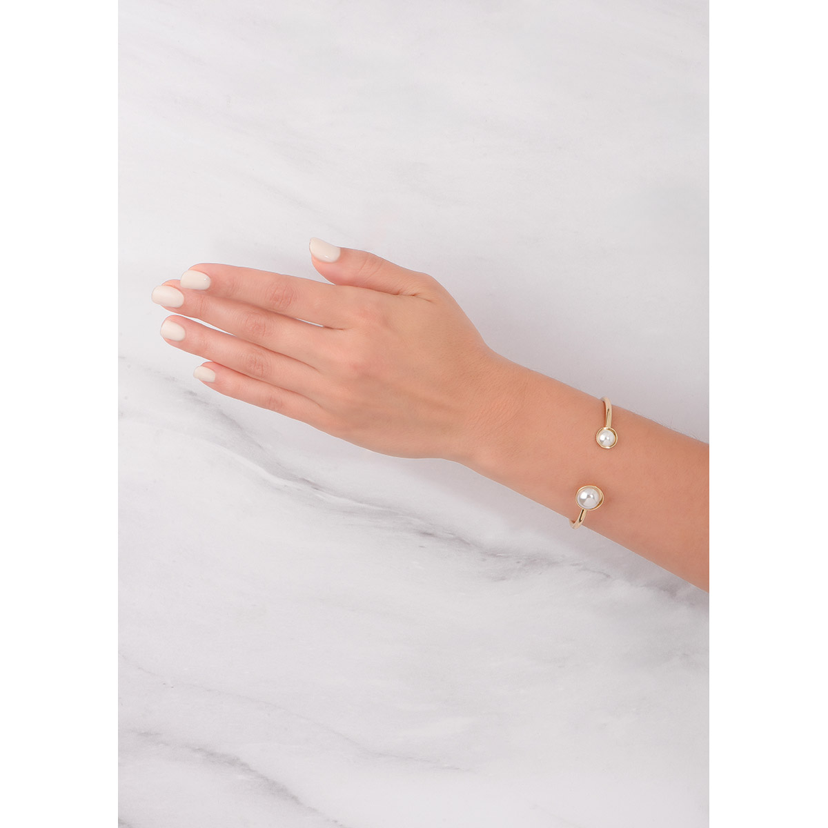 Pulsera con diseño minimalista en baño de oro; se destaca por sus dos extremos adornados con perlas cultivadas de diferentes tamaños.
-        Pulsera
-        Medida ajustable
-        Baño de Oro 18k
-        Perlas en tono cream
