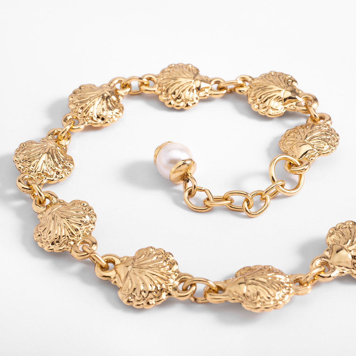 Pulsera en baño de oro con dijes texturizados diseño cadena