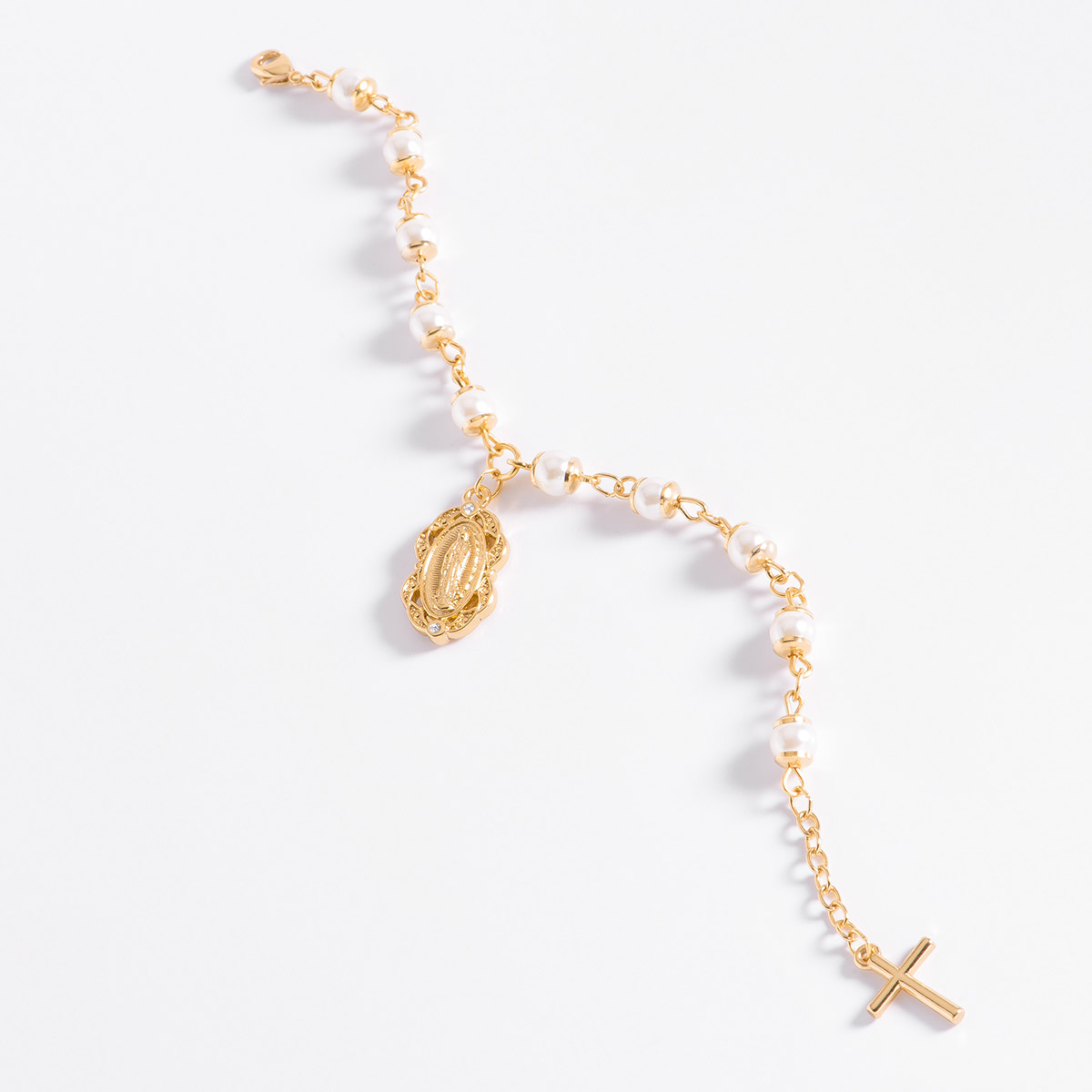 Sofisticada pulsera en baño de oro 18k,  con perlas en tono crema, que finaliza con una delicada cruz y un dije de la Virgen de Guadalupe.
-        Pulsera 18 cm + 2mc ext.
-        Baño de oro 18k
-        Perlas en tono crema
-        Piedras en tono cristal