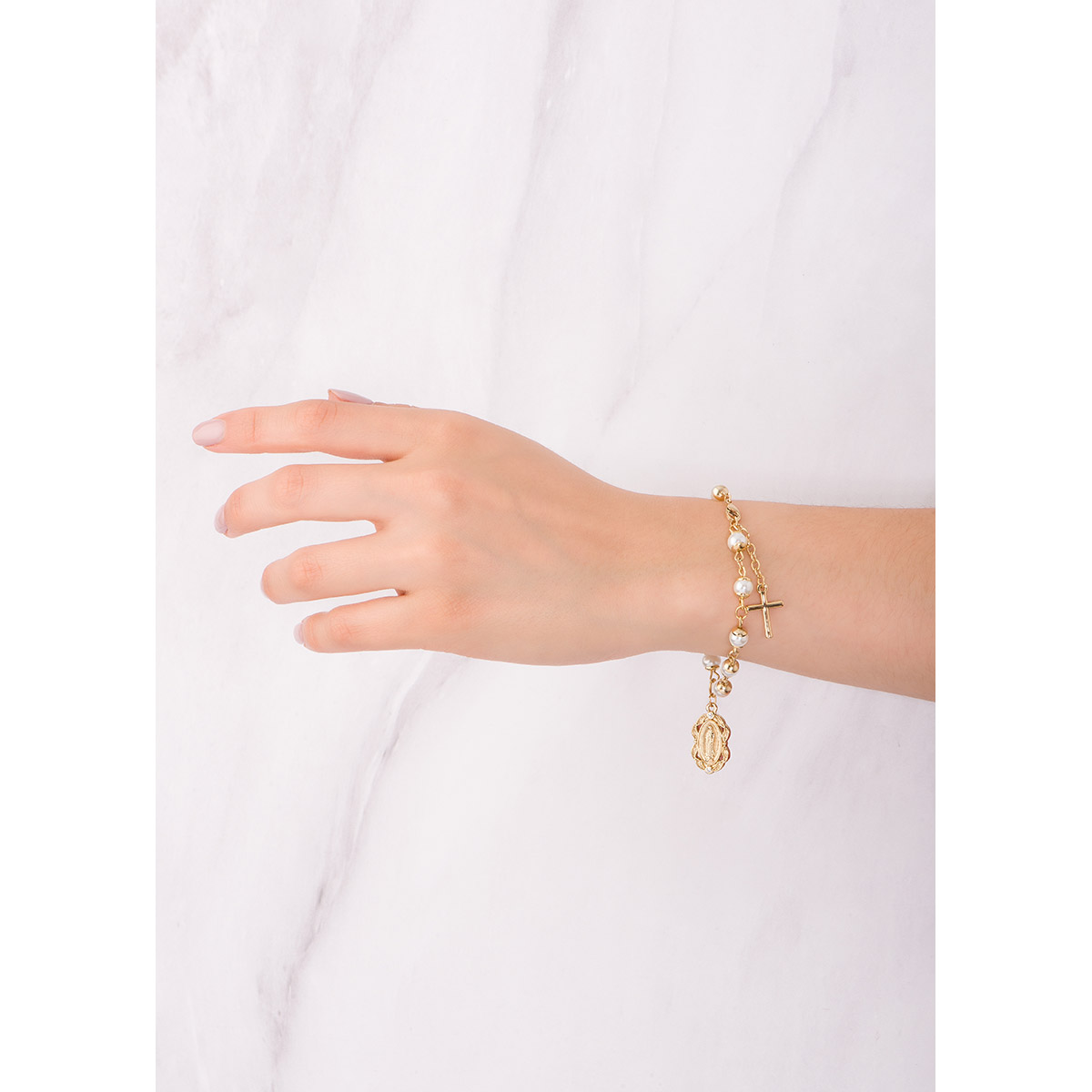 Sofisticada pulsera en baño de oro 18k,  con perlas en tono crema, que finaliza con una delicada cruz y un dije de la Virgen de Guadalupe.
-        Pulsera 18 cm + 2mc ext.
-        Baño de oro 18k
-        Perlas en tono crema
-        Piedras en tono cristal