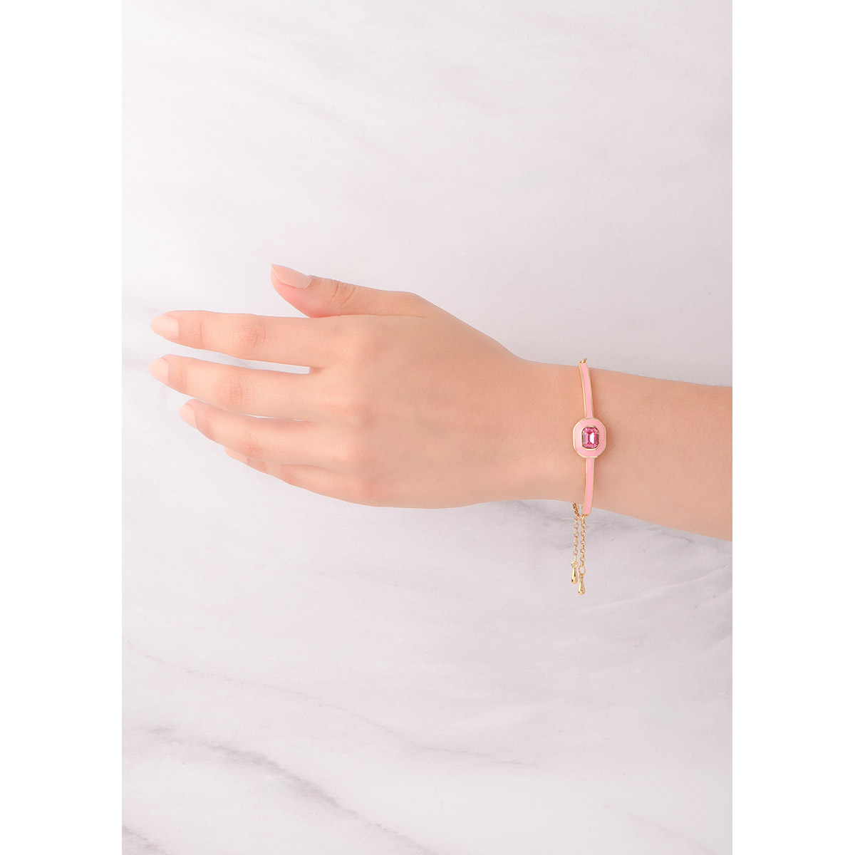 Linda pulsera ajustable en baño de oro, con un diseño rectangular y un centro superpuesto con una forma geométrica en esmalte rosado, incrustada con una piedra en tono rosa. Combínala con tu collar y anillo.
-        Pulsera
-        Medida ajustable
-        Piedra en tono rosa
-        Esmalte en tono rosa
