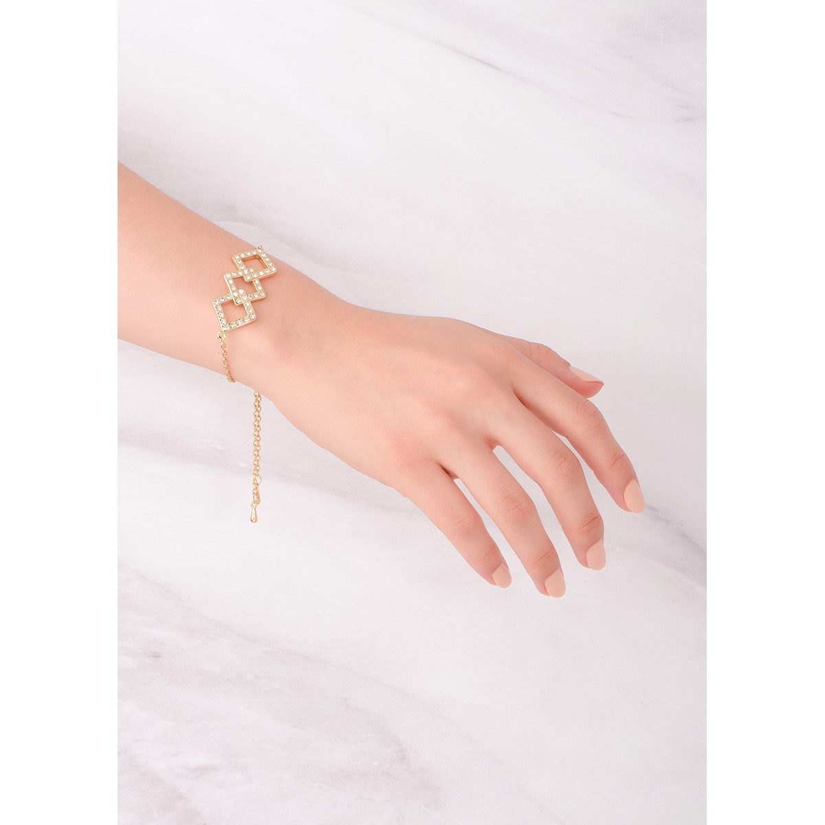 Elegante pulsera de medida ajustable en baño de oro, con tres formas geométricas entrelazadas, cada una con piedras en tono cristal. Combínala con tu collar.
-        Pulsera
-        Medida ajustable
-        Baño de Oro 18k
-        Piedras en tono cristal

