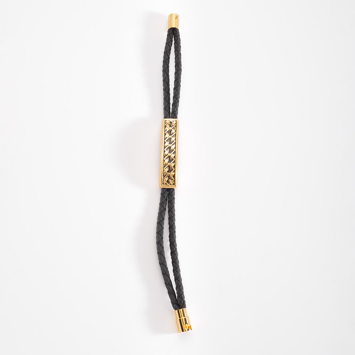 Brazalete con cordón en tono negro, en donde resalta una forma rectangular en baño de oro, con diseño celta.
-        Pulsera
-        21 cm
-        Baño de Oro
-        Esmalte en tono negro
-        Cordón en tono negro
