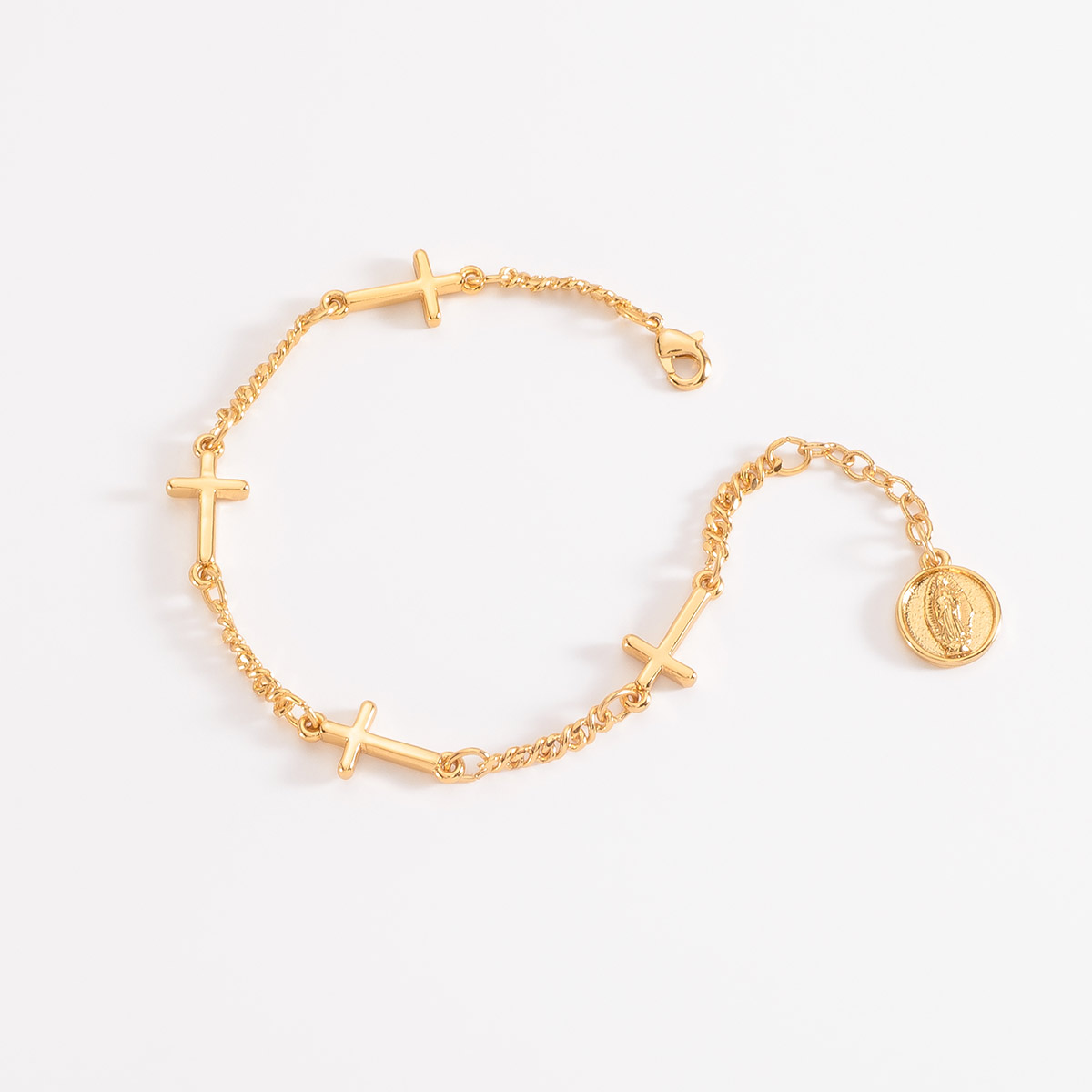 Delicada pulsera en baño de oro, con dijes de finas cruces y con una medalla de la Virgen de Guadalupe.
-        Pulsera
-        18 cm + 2 cm ext.
-        Baño de Oro 18k
