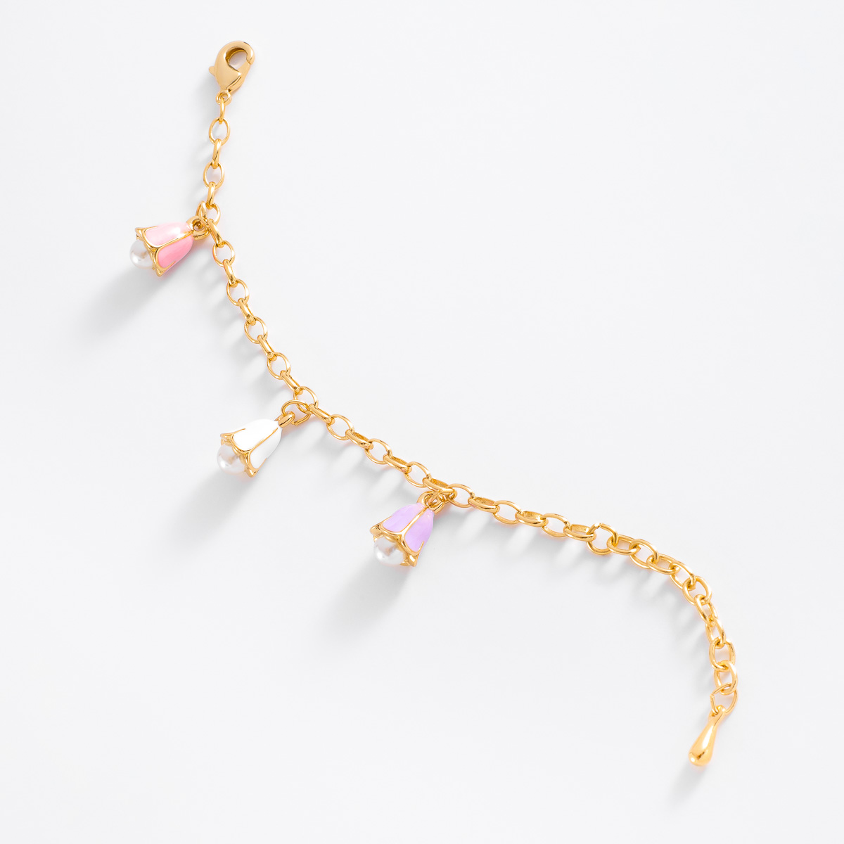 Una bonita pulsera con encantadores dije con forma de campaña floral, en baño de oro y con esmalte rosa pastel, el diseño se acentúa con una perla en tono crema. Completa el set con collar y aretes para las niñas consentidas.
-        Pulsera 
-        13 cm + 3cm ext.
-        Baño de Oro 18k
-        Perla en tono cream
-        Esmalte en tono rosa pastel
