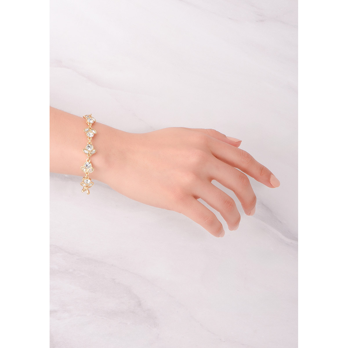 Sofisticada pulsera en baño de oro 18k, su diseño de piedras incrustadas en tono cristal hace reminiscencia a formas florales.
-        Pulsera 
-        18 cm + 2 cm ext.
-        Baño de Oro 18k
-        Piedras en tono cristal
