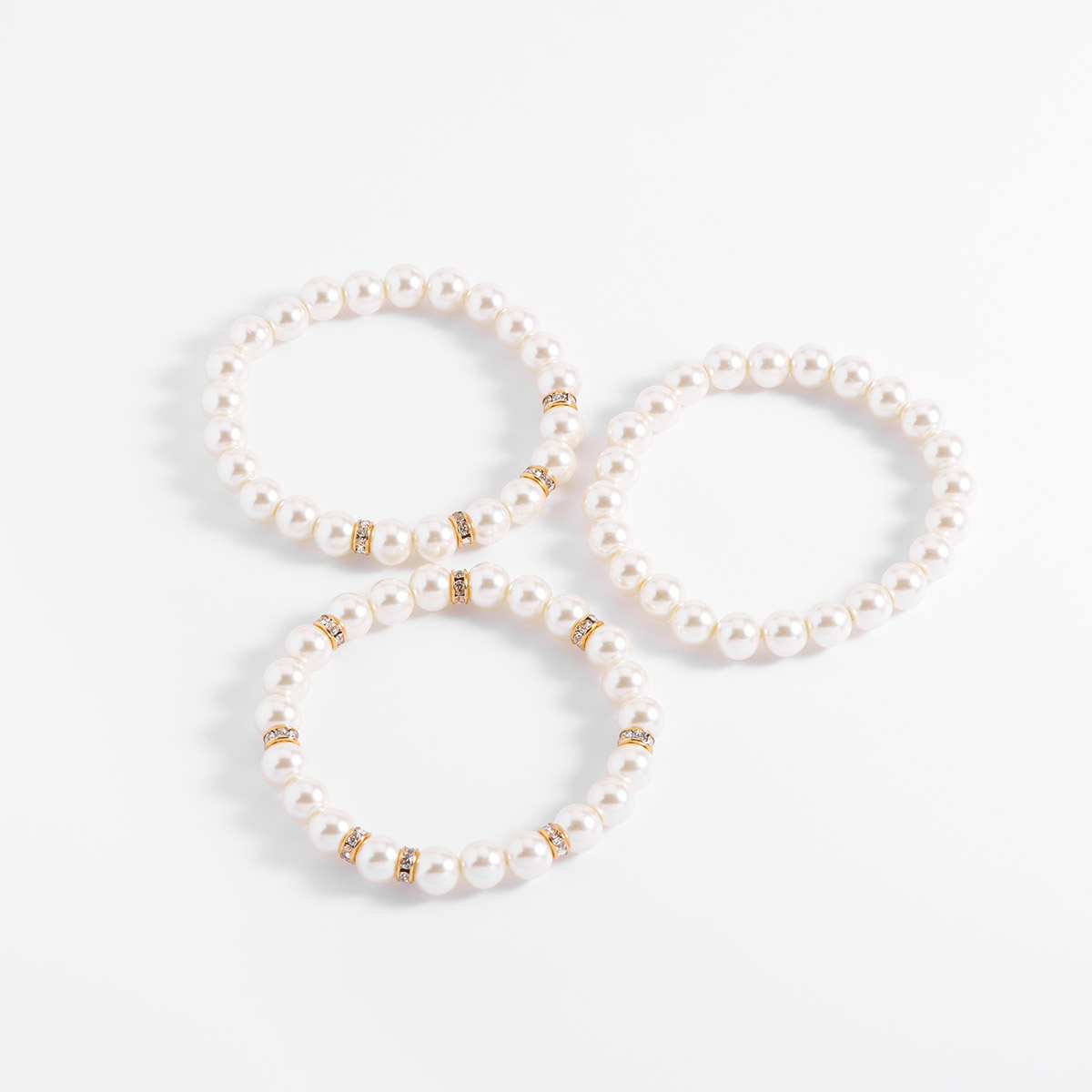 Set de tres pulseras con diseño elástico, con perlas en tono cream en baño de oro e incrustada en con piedras en tono cristal. Combínalas con tu collar y aretes.
-        Set de 3 pulseras
-        Medida única
-        Baño de Oro 18k
-        Perlas en tono cream
-        Piedras en tono cristal
