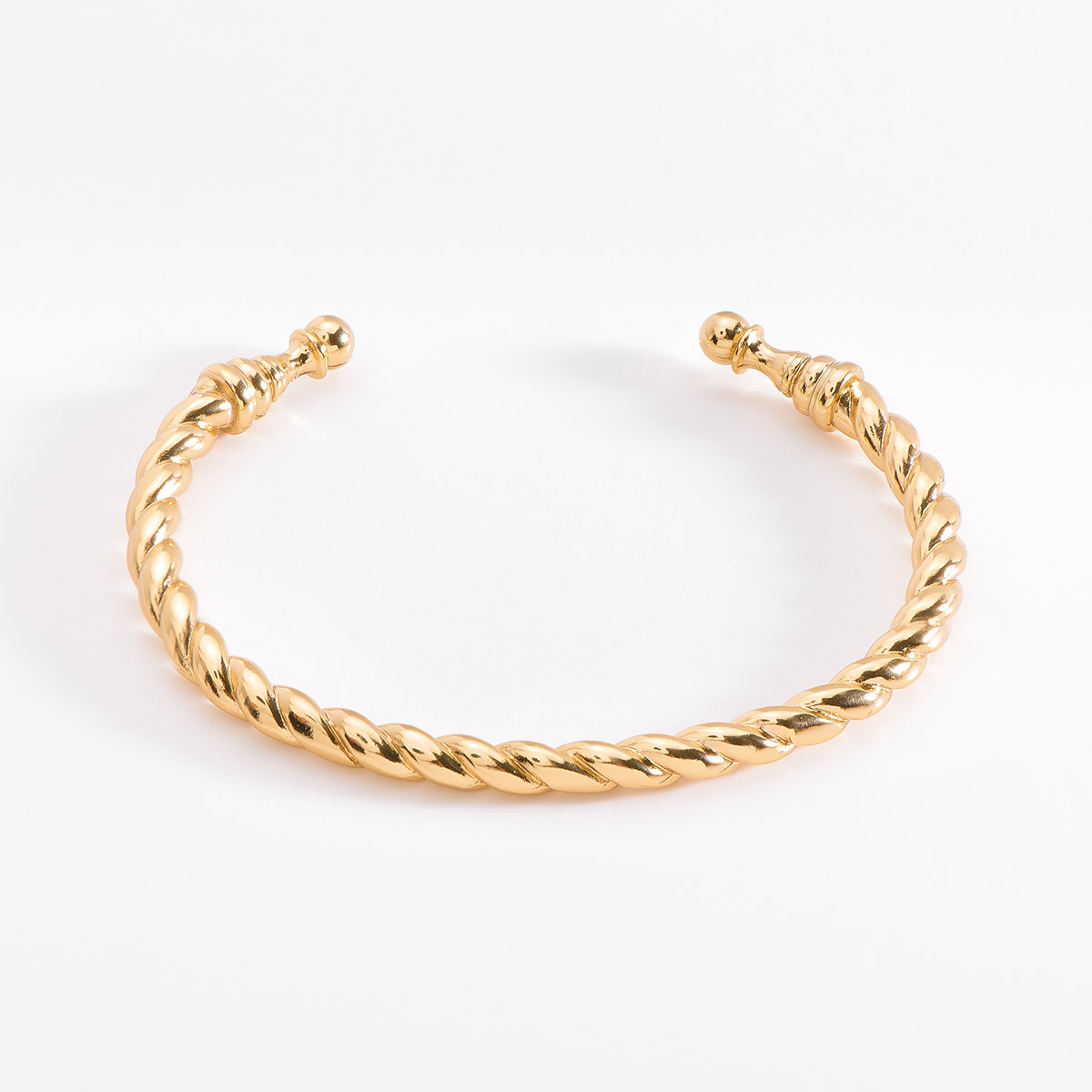 Elegante brazalete de medida ajustable, con un diseño trenzado y extremos redondeados, en baño de oro.
-        Pulsera
-        Medida ajustable
-        Baño de Oro 18k
