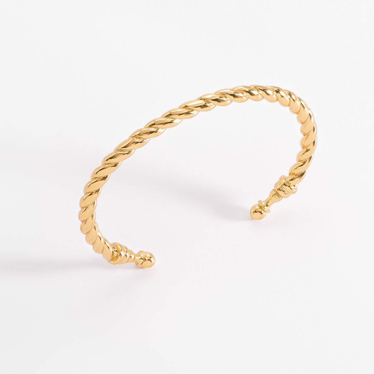 Elegante brazalete de medida ajustable, con un diseño trenzado y extremos redondeados, en baño de oro.
-        Pulsera
-        Medida ajustable
-        Baño de Oro 18k
