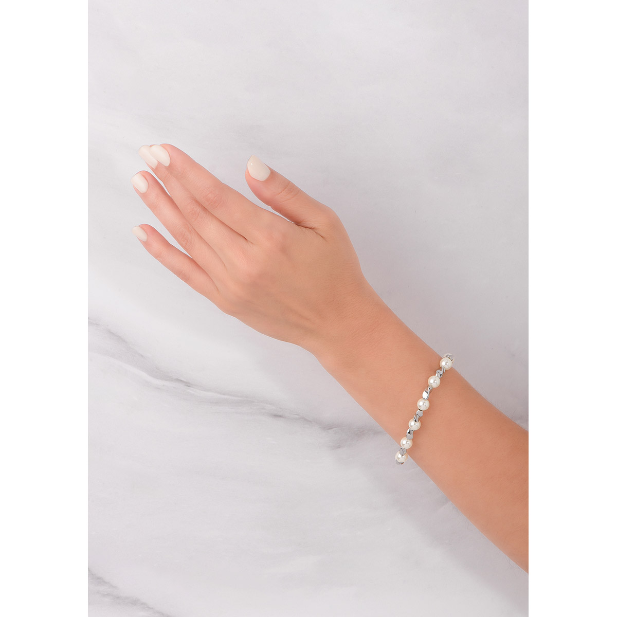 Esta pulsera presenta un diseño que contrasta perlas blancas y eslabones en baño de platino de formas fluidas. Los eslabones torcidos se intercalan con las perlas, creando un equilibrio perfecto. Combínala con tus aretes.
-        Pulsera
-        Medida única
-        Baño de Platino
-        Perlas en tono cream.
