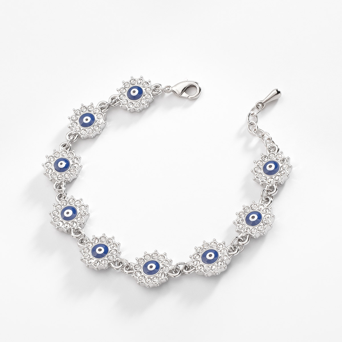 Pulsera en baño de oro, con dijes en diseño floral, incrustados con piedras en tono cristal y un ojo turco al centro, con esmalte en tono azul, blanco y negro. Completa tu set con aretes y collar de la misma colección.
-        Pulsera
-        18 cm + 2 cm ext.
-        Baño de Platino
-        Piedras en tono cristal
-        Esmalte en tono azul, blanco y negro 
