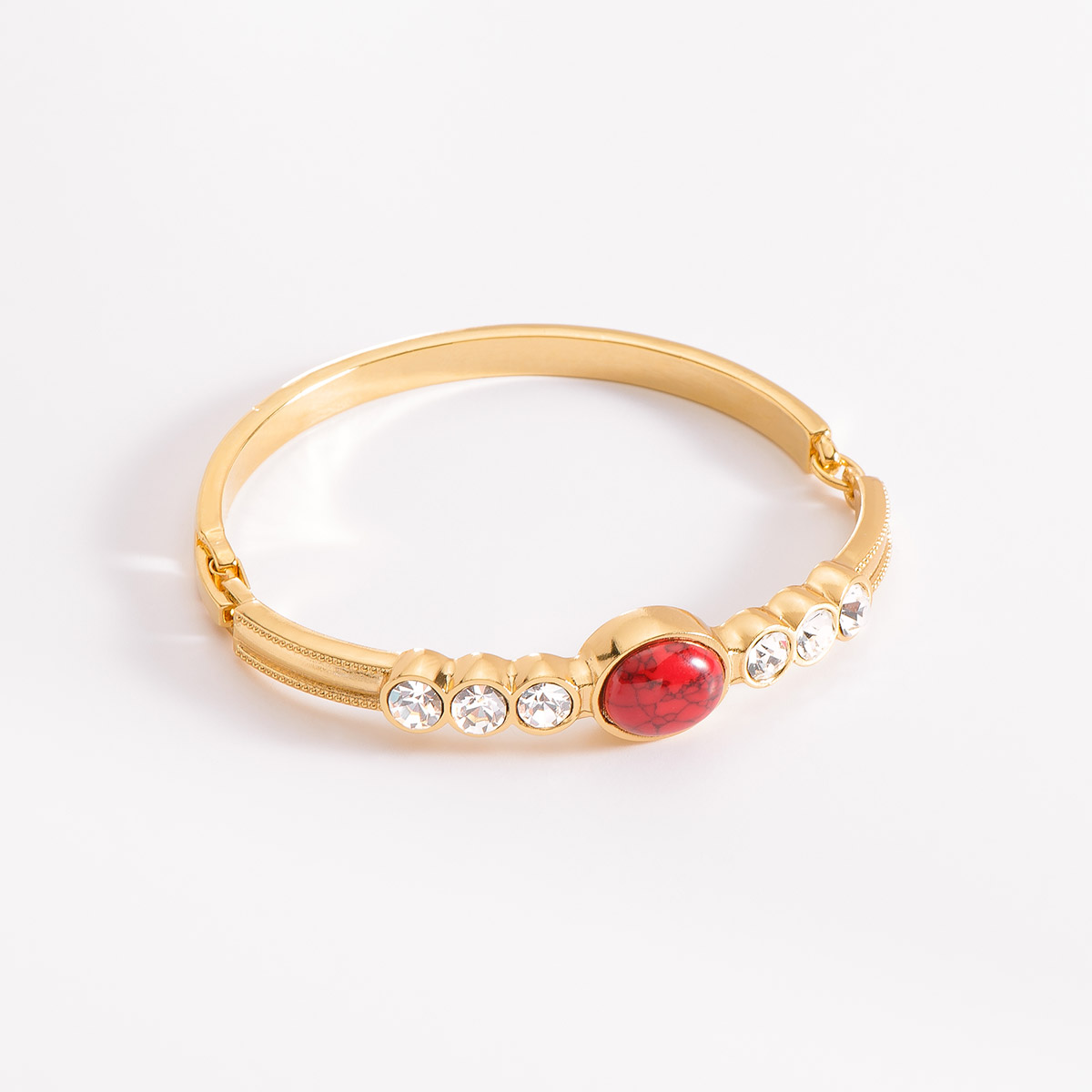 Pulsera en baño de oro, destacando al centro una pieza incrustada por una piedra circular en tono rojo, y en ambos lados, tres piedras en tono cristal. Combínala con tus aretes, anillo y collar.
-        Pulsera
-        Medida única
-        Baño de Oro 18k
-        Piedras en tono rojo y cristal