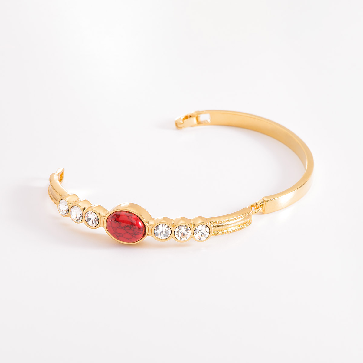 Pulsera en baño de oro, destacando al centro una pieza incrustada por una piedra circular en tono rojo, y en ambos lados, tres piedras en tono cristal. Combínala con tus aretes, anillo y collar.
-        Pulsera
-        Medida única
-        Baño de Oro 18k
-        Piedras en tono rojo y cristal