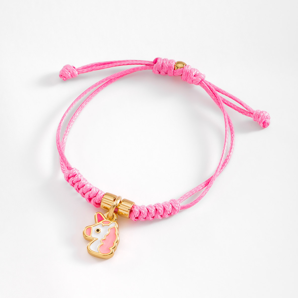 Acompaña tus aventuras con esta pulsera con cordón en tono rosa, con un dije en forma de unicornio.
-        Pulsera
-        Medida ajustable
-        Baño de Oro 18k
-        Esmalte en tono rosa, blanco y negro
-        Cordón en tono rosa
