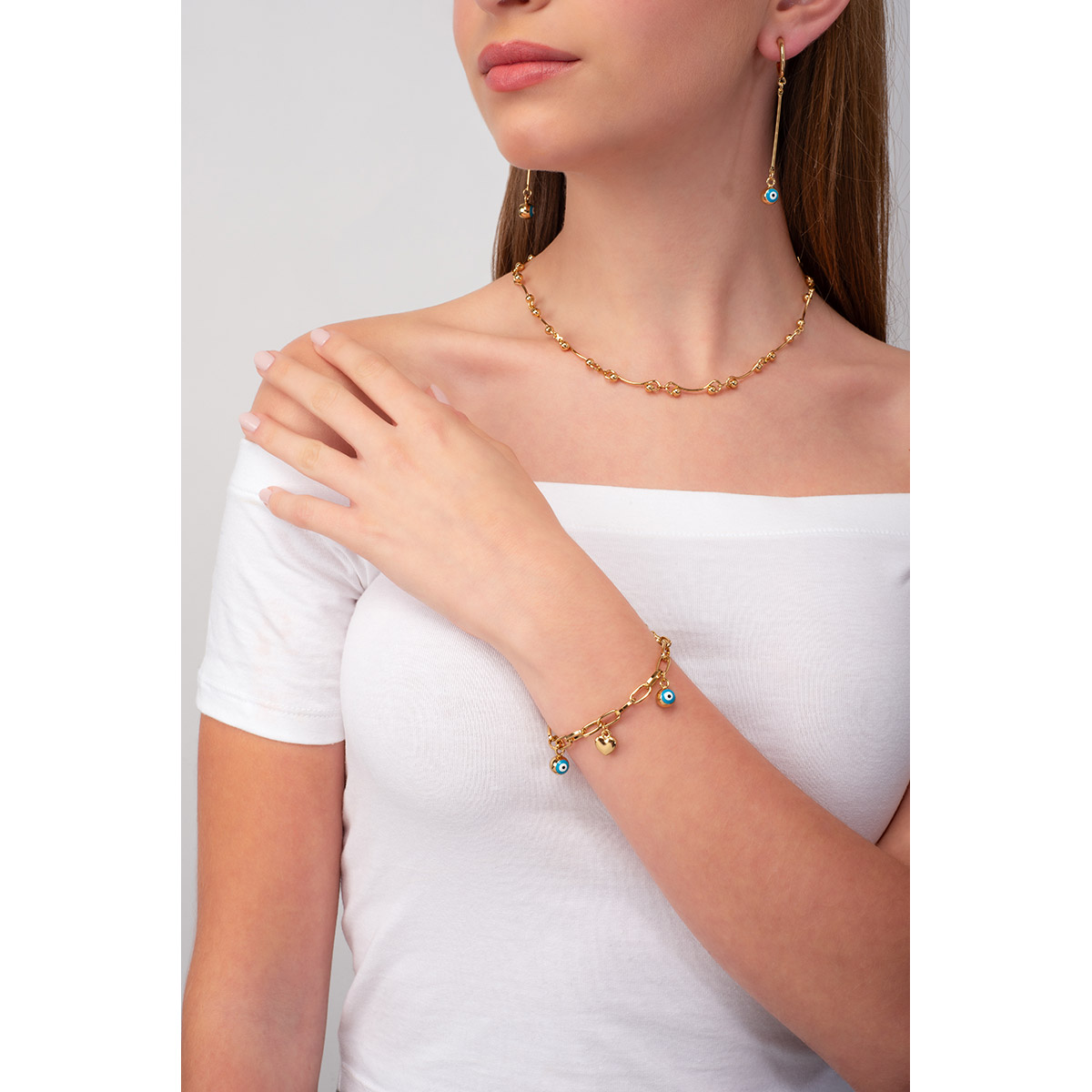 El amor y la buena fortuna se conjugan en esta pulsera en baño de oro, con cincos dijes de dos diseños diferentes: un corazón y un ojo turco. Combínala con tus aretes y collar.
-        Pulsera
-        18 cm + 2 cm ext.
-        Baño de Oro 18k
-        Esmalte en tono azul claro, blanco y negro