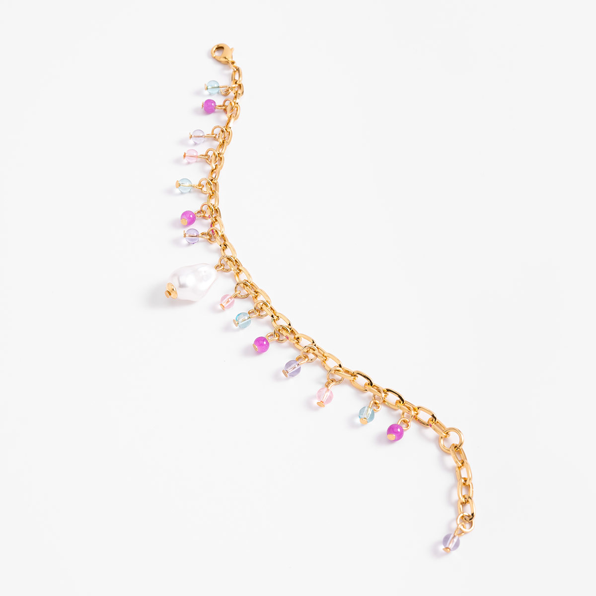 Pulsera en baño de oro con dijes en tonos crema, lila, rosa y aguamarina que aporta un toque fresco y sofisticado a cualquier look.