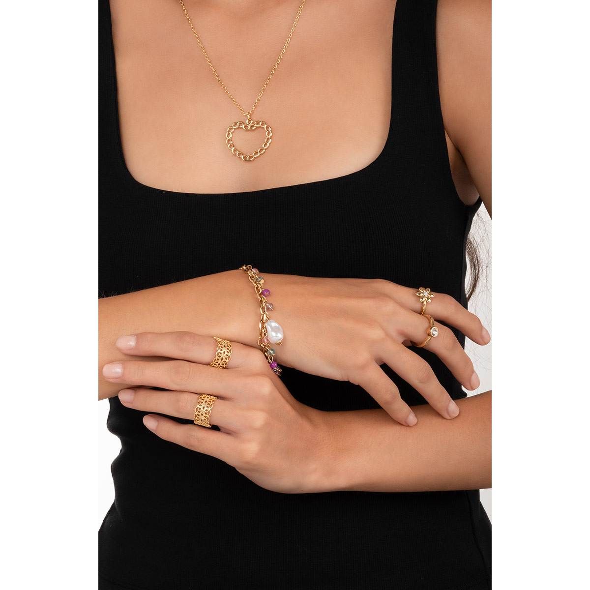 Pulsera en baño de oro con dijes en tonos crema, lila, rosa y aguamarina que aporta un toque fresco y sofisticado a cualquier look.