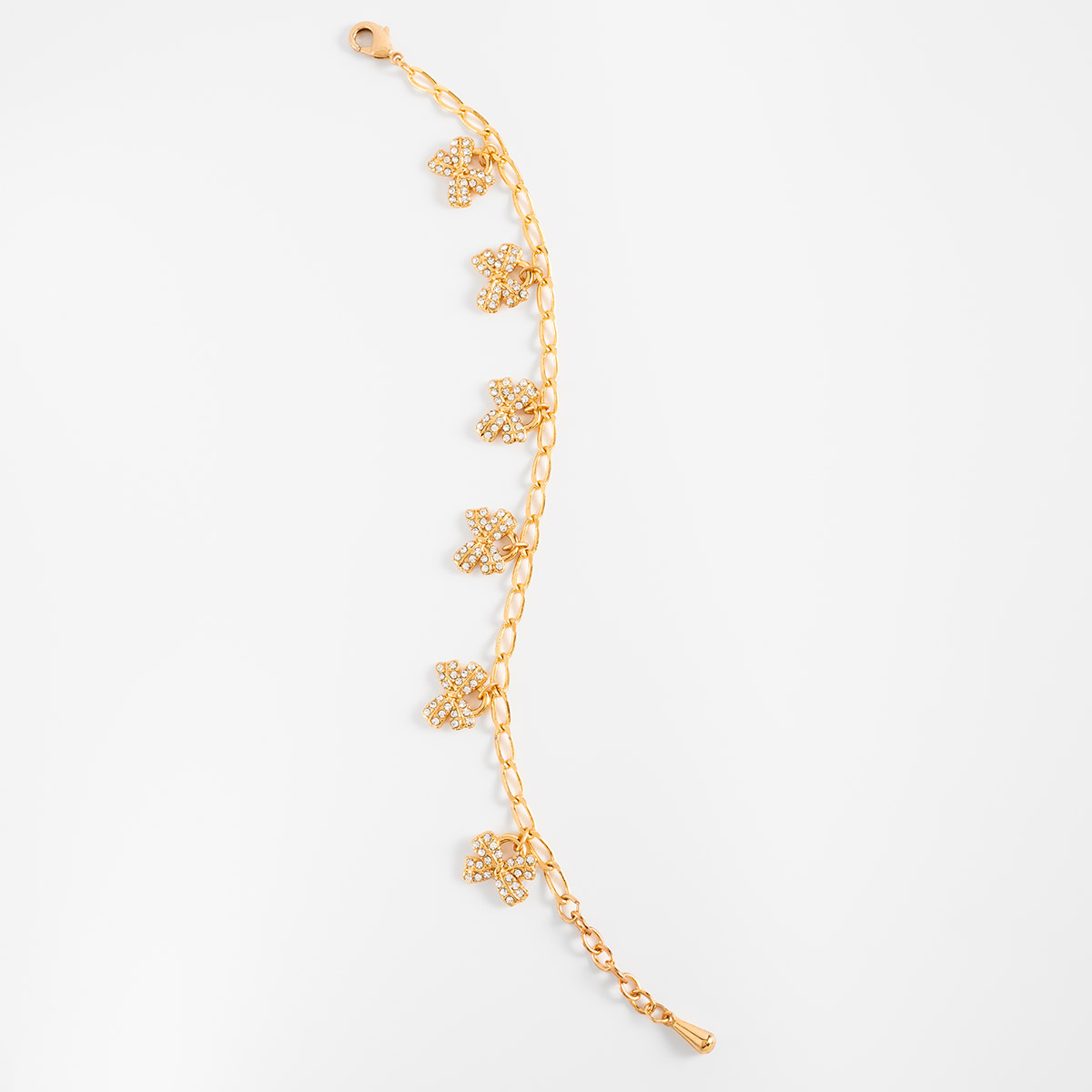 Pulsera en baño de oro dijes moño piedras toque brillante