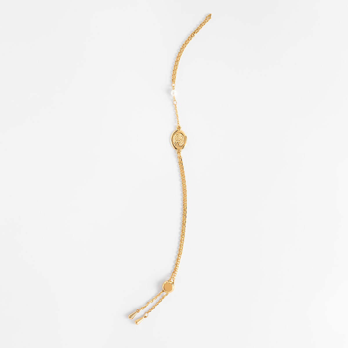 Pulsera en baño de oro medallón central perla crema cadena fina