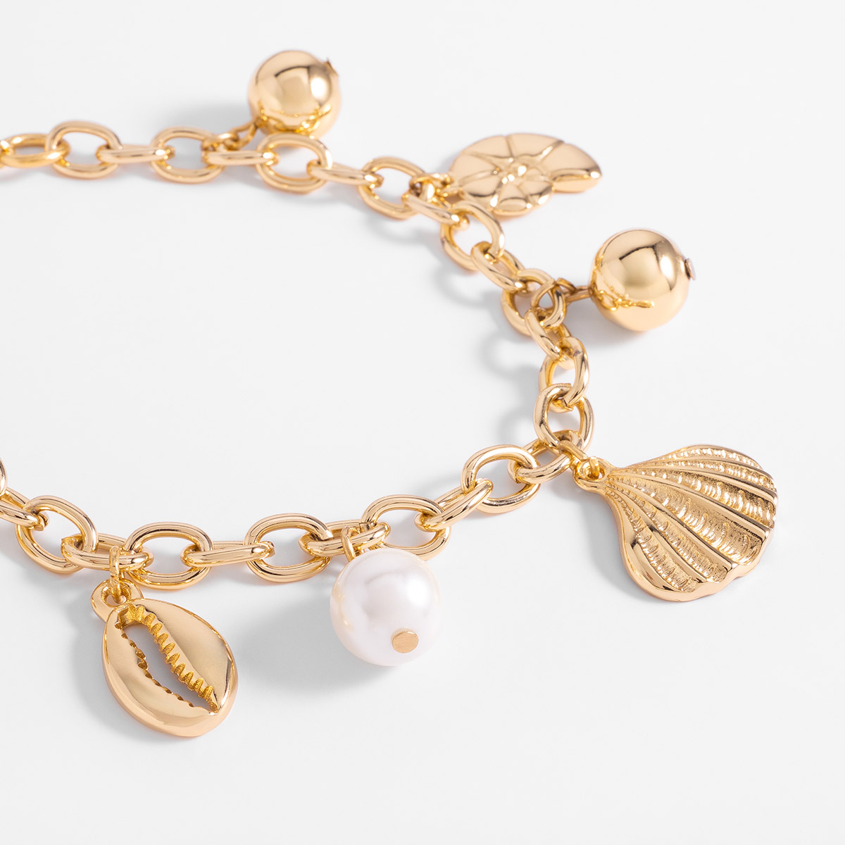Pulsera en baño de oro con dijes marinos y perla sintética