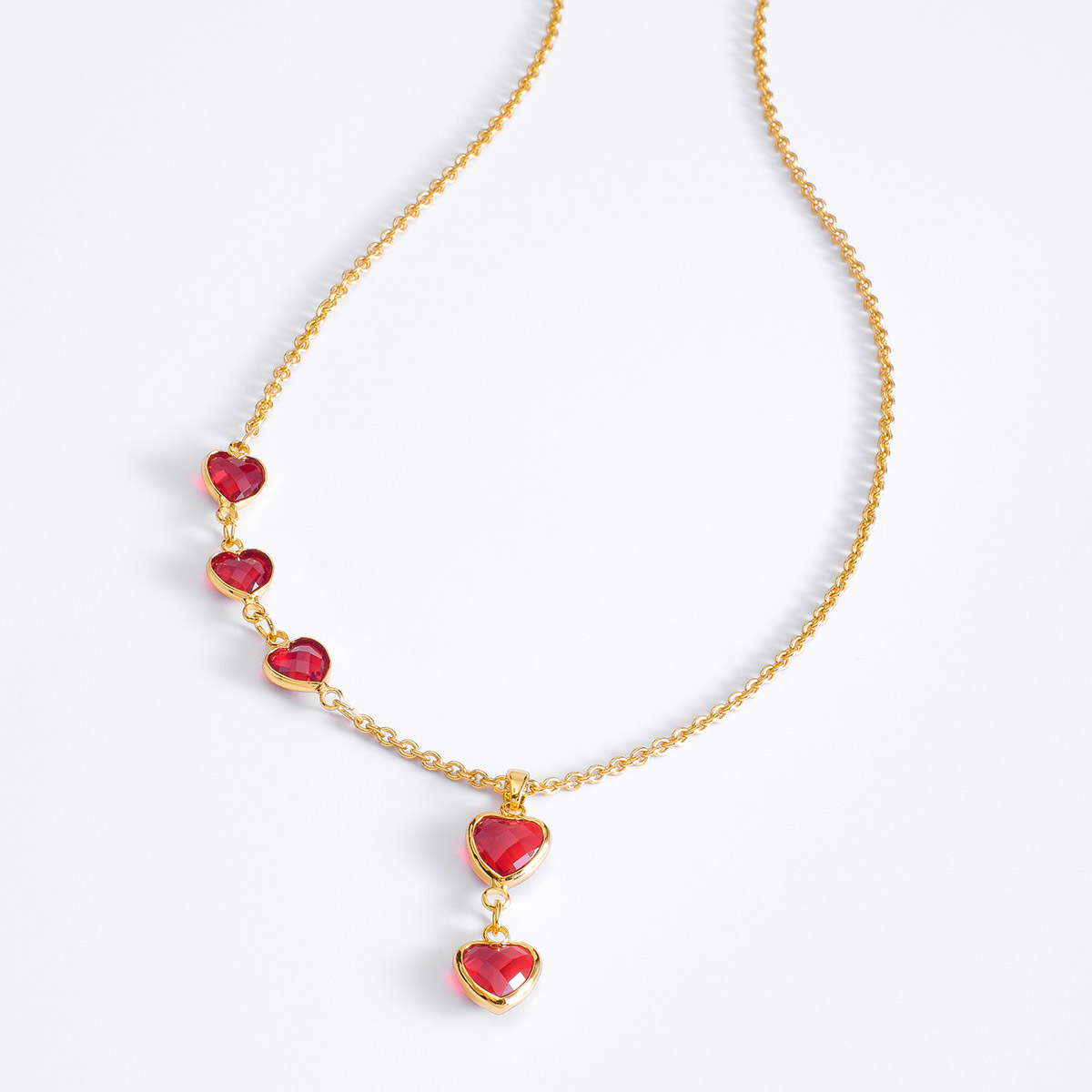 El amor y la elegancia se acompañan con este hermoso collar adornado con cinco dijes de  en forma de corazón  en tono rojo.
-Collar con Dije
-Oro 18k
-Piedras en tono rojo