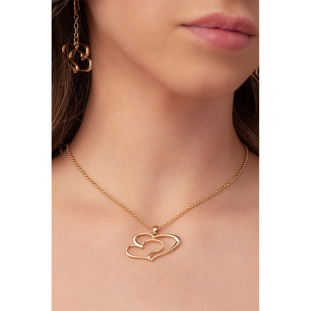 Collar en baño de oro, con un dije de líneas formando un doble corazón. Combínalo con tus aretes.
-        Collar
-        40 cm + 10 cm ext.
-        Baño de Oro 18k