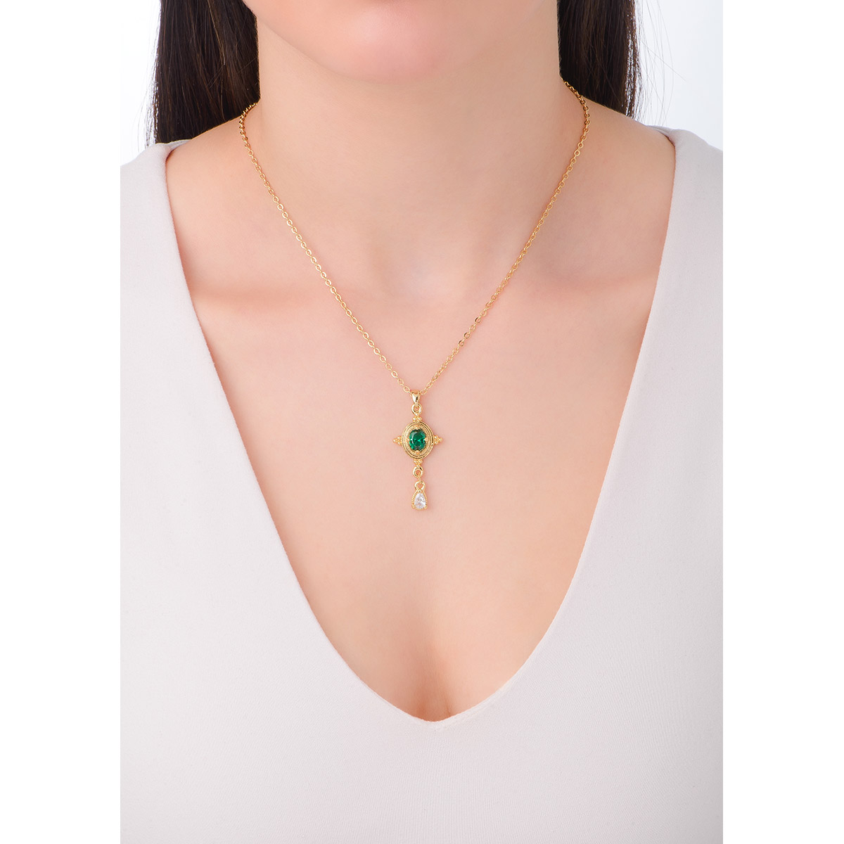 Encantador collar con dije en baño de oro 18k con dije ovalado. En el centro del dije, nuestra exclusiva piedra Diamonice en tono verde esmeralda, rodeada por un elaborado marco dorado con detalles ornamentales. De el, cuelga una pequeña piedra en tono cristal, en forma de gota, añadiendo un toque de movimiento y elegancia.                                                                                        -        Collar
-        42 cm + 10 cm ext.
-        Baño de oro
-        Piedra Diamonice en tono esmeralda y cristal