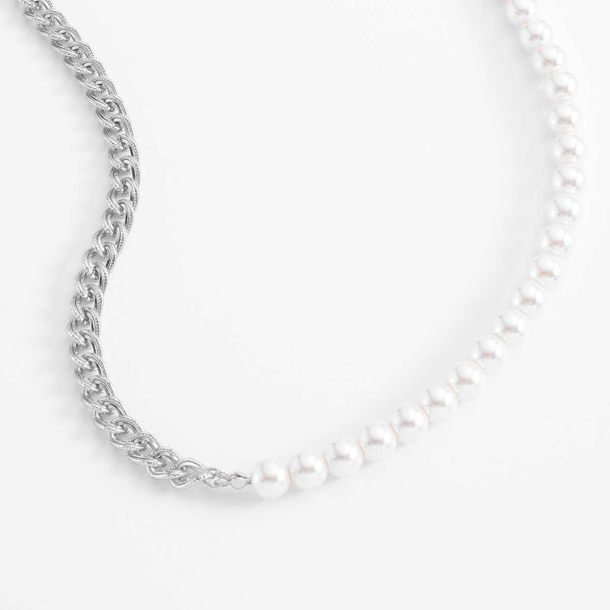 Cautivador collar de eslabones entrelazados en baño de platino, combinando en perfecta simetría con perlas en tono crema.
-        Collar
-        50 cm
-        Baño de Platino
-        Perlas en tono crema
