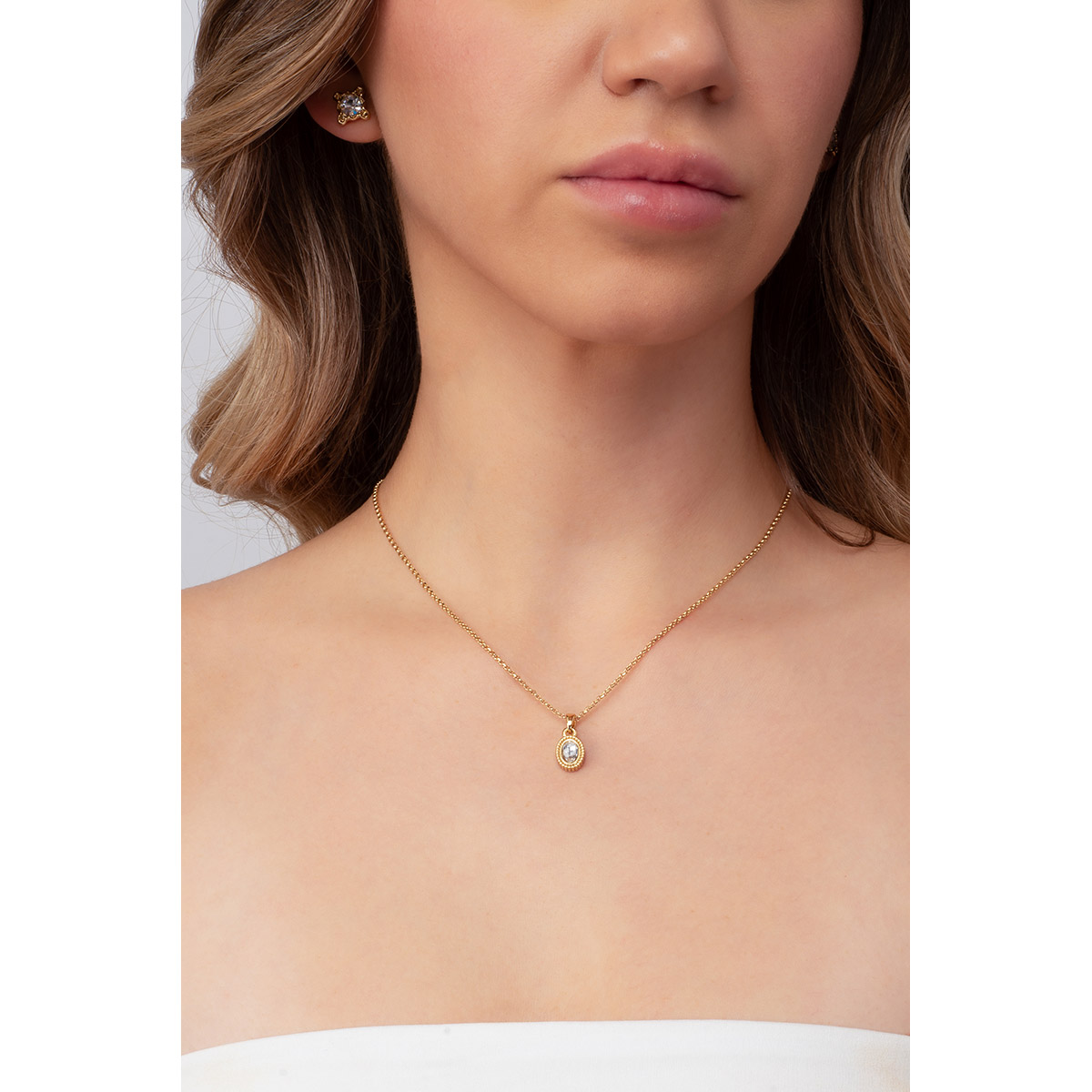 Collar con dije ovalado, texturizado en baño de oro. Con una piedra incrustada en tono cristal.
-        Collar
-        41 cm + 10 cm ext.
-        Baño de Oro 18k
-        Piedras en tono cristal
