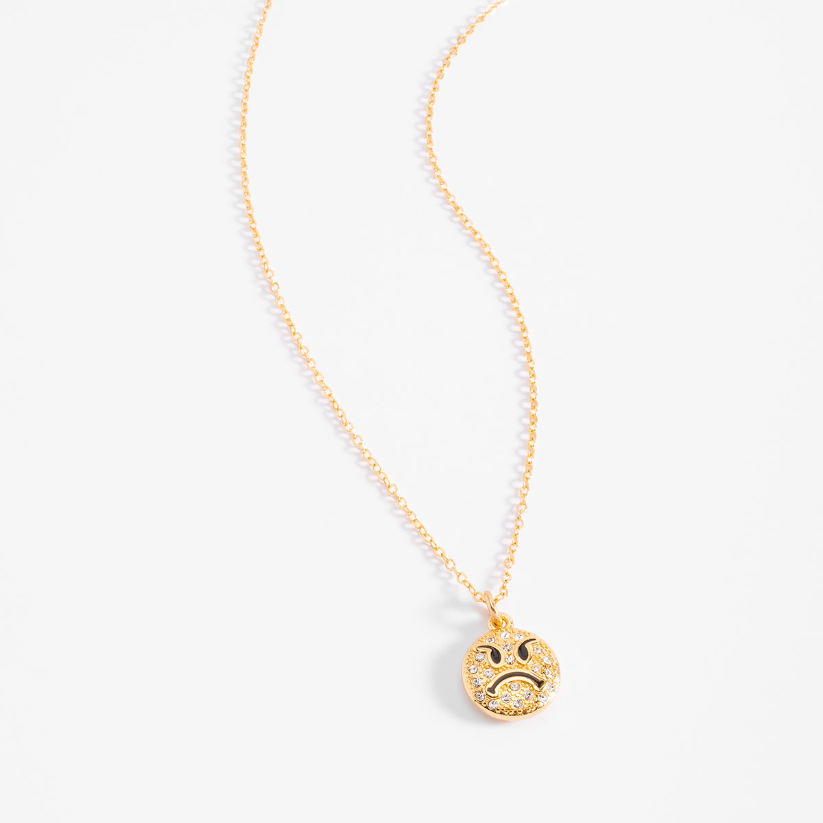 Luce un collar en baño de oro con dije de carita sonriente brillante que aporta un toque juvenil y llamativo a cualquier atuendo.