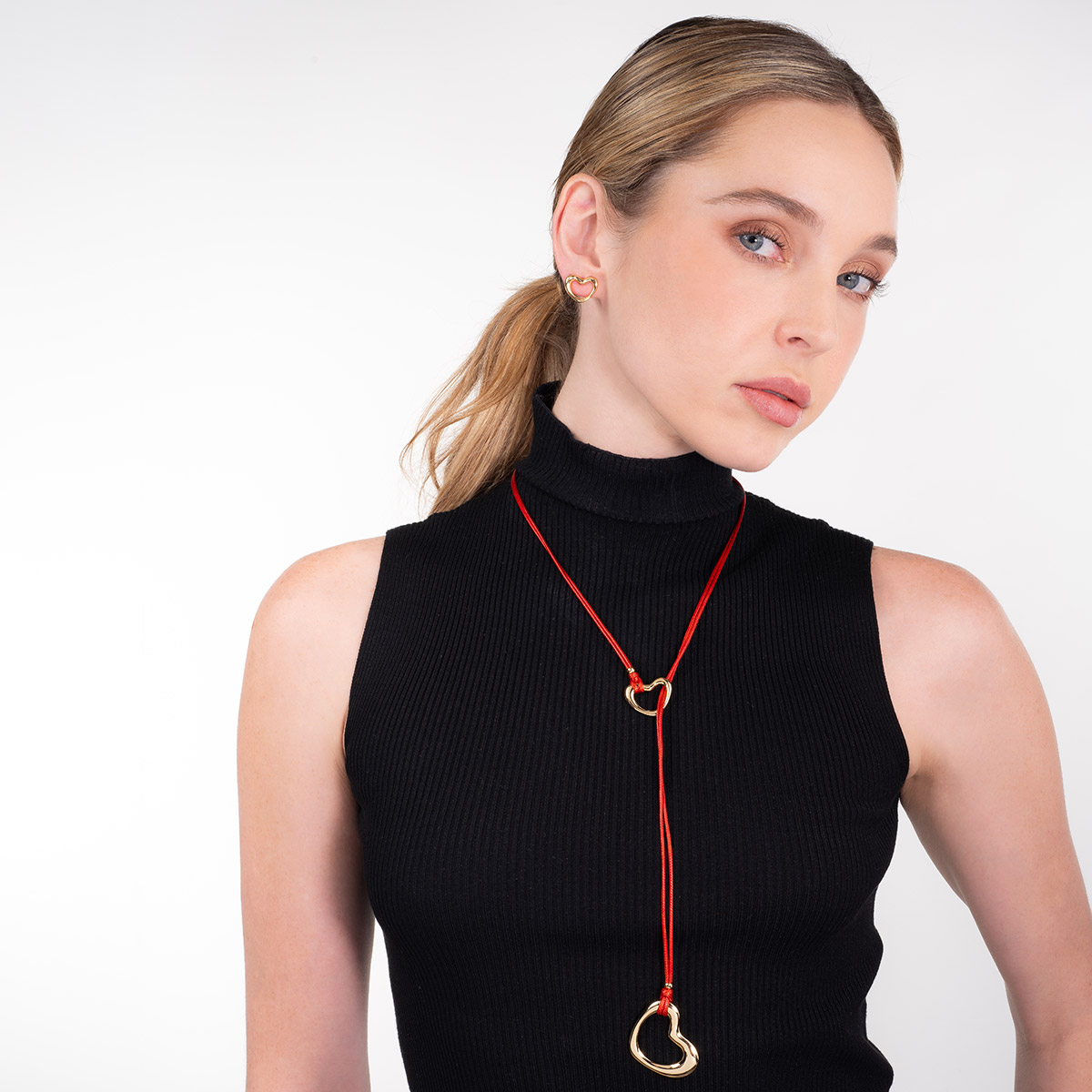 Collar en baño de oro con dijes de corazón y cordón rojo