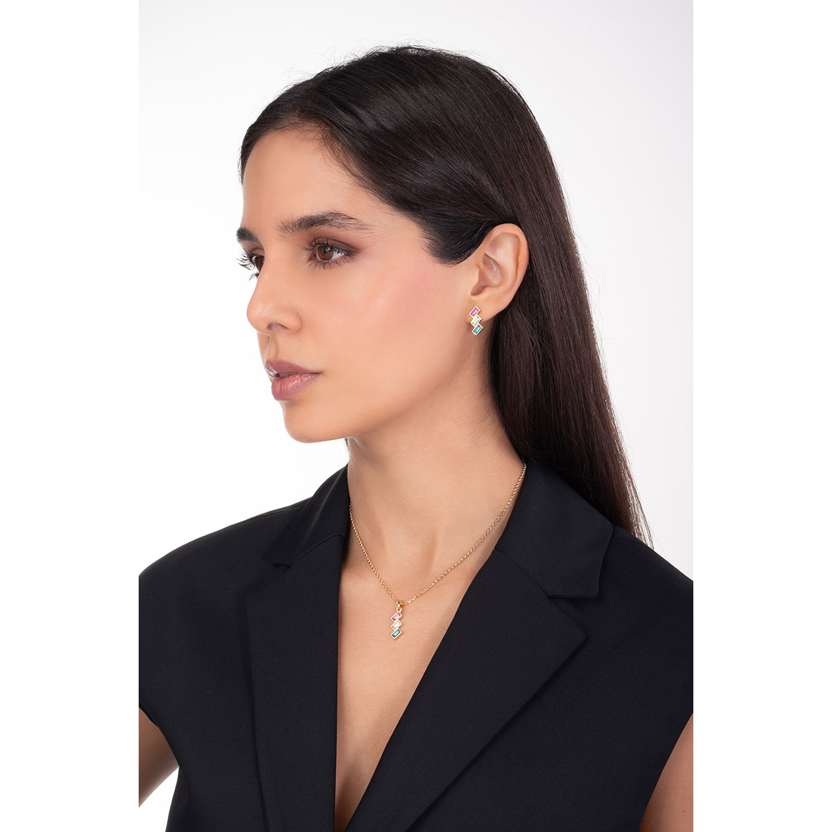 Collar en baño de oro con dije geométrico y piedras con toque brillante en tonos fucsia, verde claro y azul oscuro.