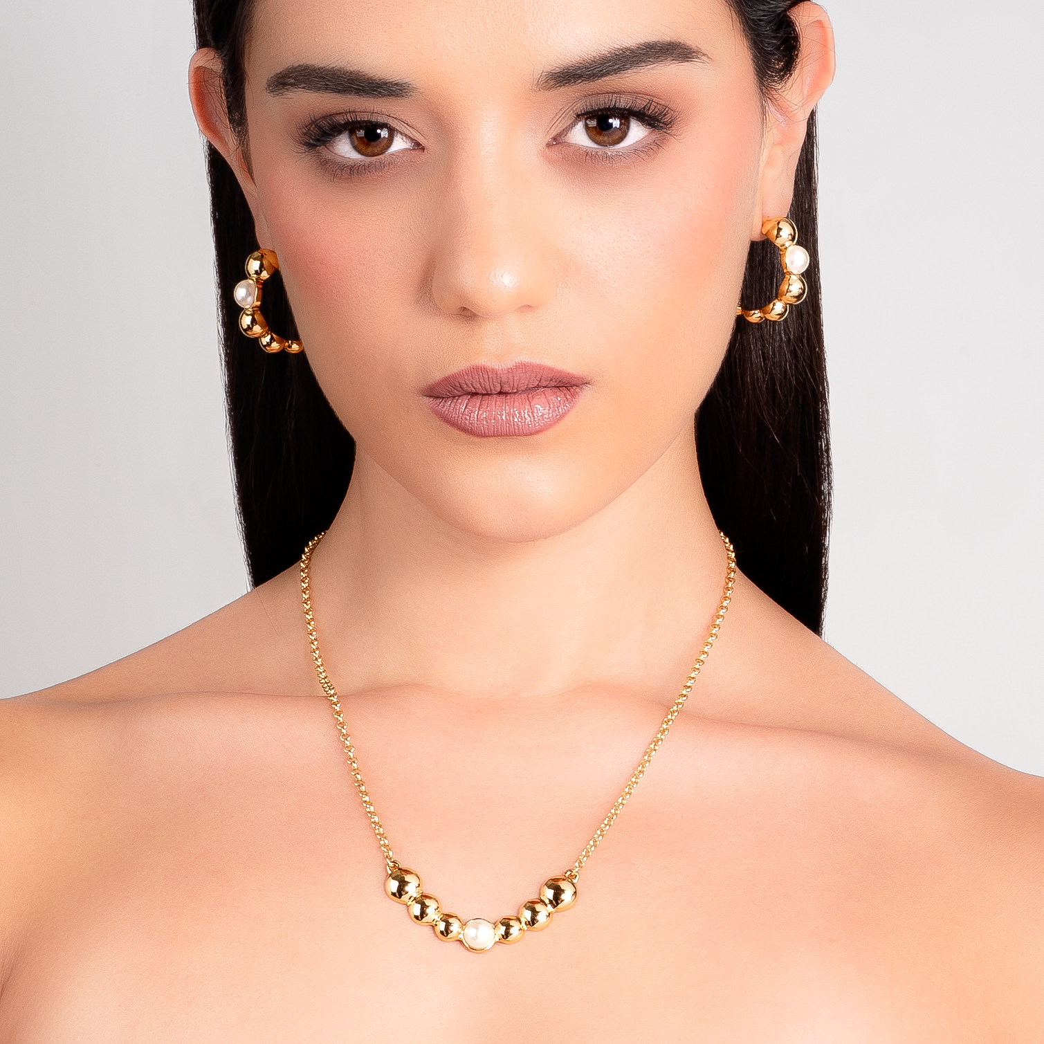 Collar en baño de oro con esferas metálicas y perla central en tono crema