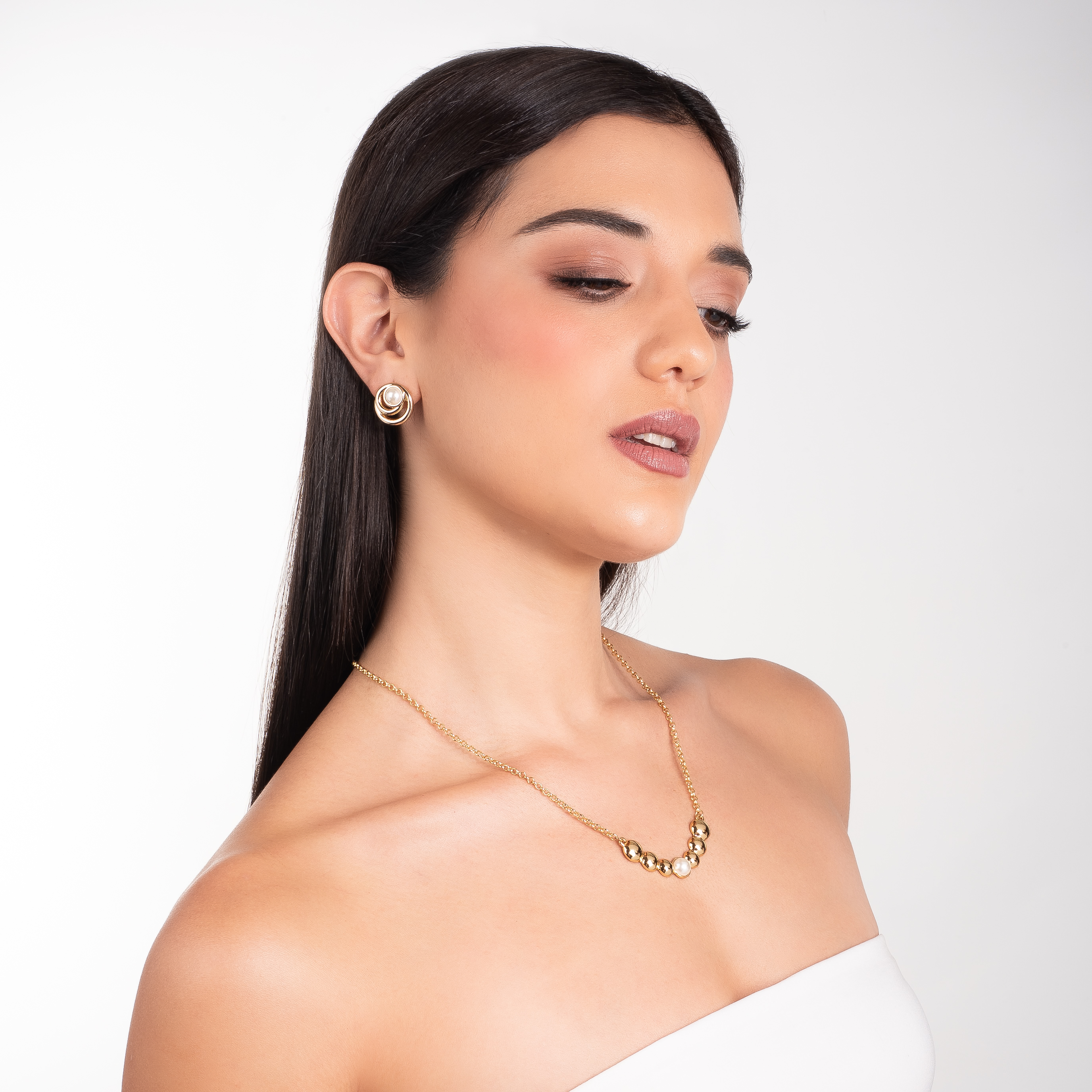 Collar en baño de oro con esferas metálicas y perla central en tono crema