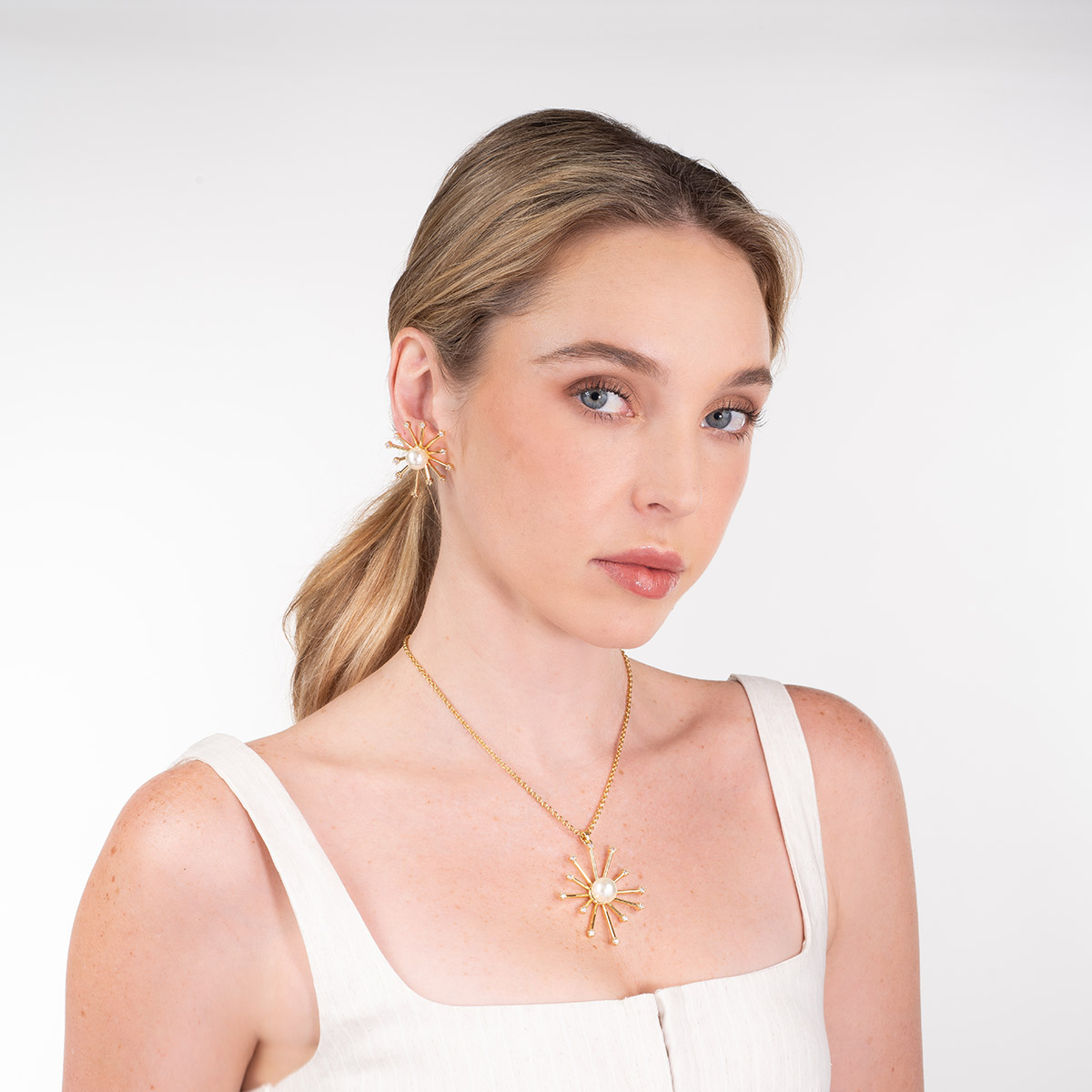 Collar en baño de oro con dije radial perla y piedras brillante
