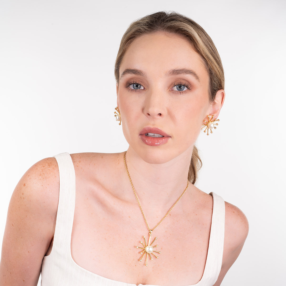 Collar en baño de oro con dije radial perla y piedras brillante