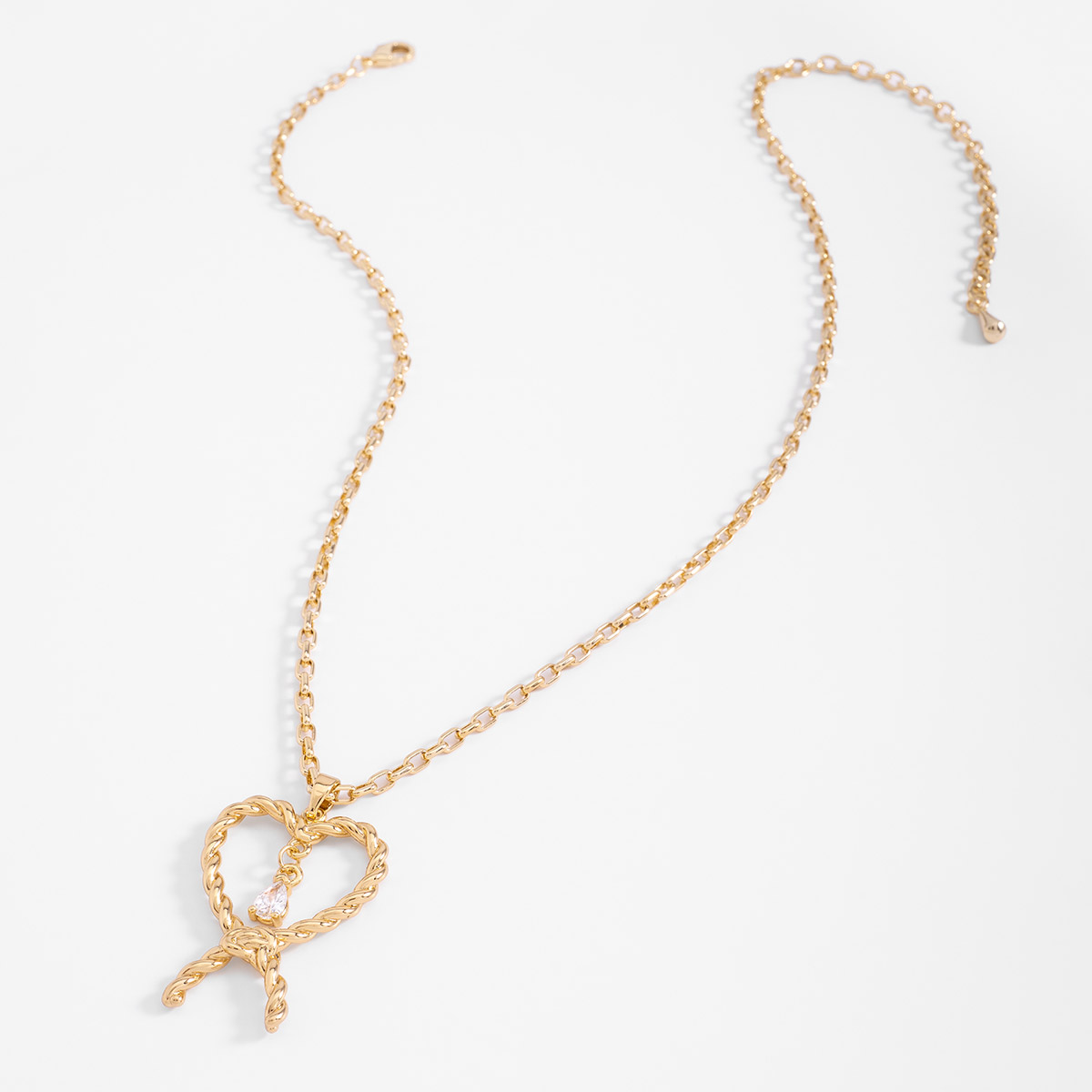 Collar en baño de oro con dije lazo retorcido y piedra brillante