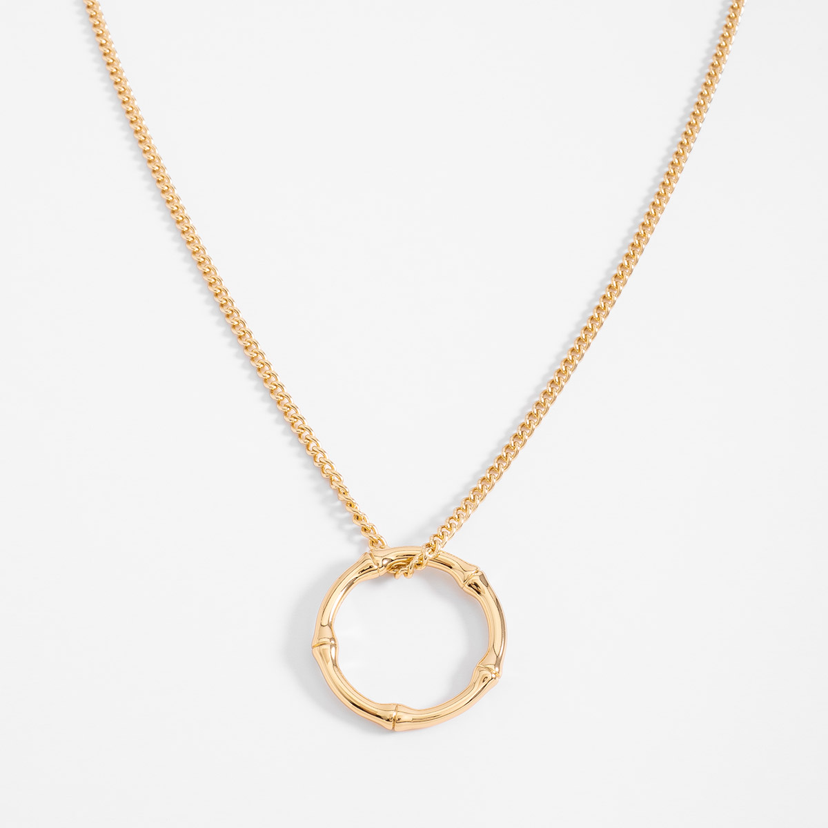 Collar en baño de oro con dije circular estilo bambú