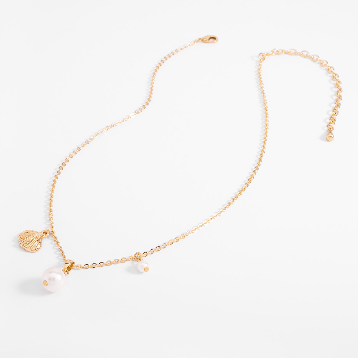 Collar en baño de oro con dije de concha y perlas sintéticas