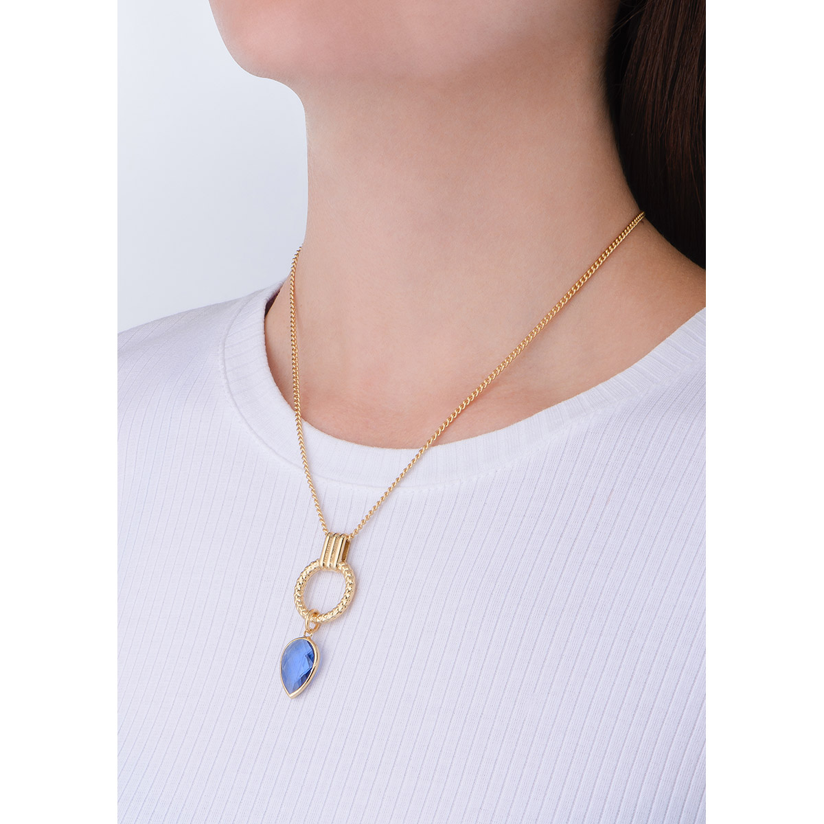 Refinado collar en baño de oro con un diseño de dije especial; un aro texturizado de donde cuelga un dije con piedra en tono azul.
-        Collar
-        42 cm + 10 cm ext.
-        Baño de Oro 18k
-        Piedra en tono azul
