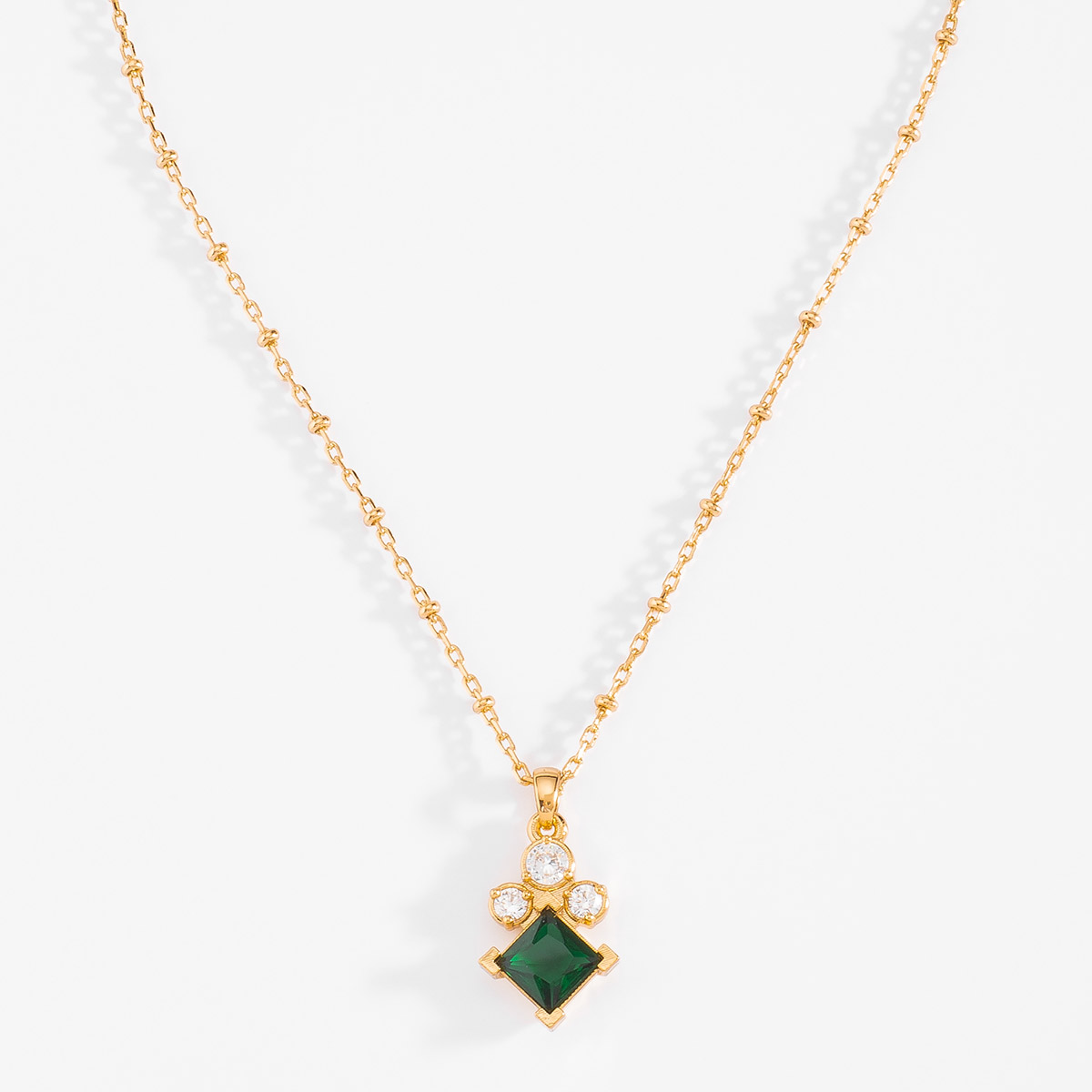 Collar de 42 cm más 10 cm de extensión en baño de oro con piedra diamonice en tono cristal y esmeralda