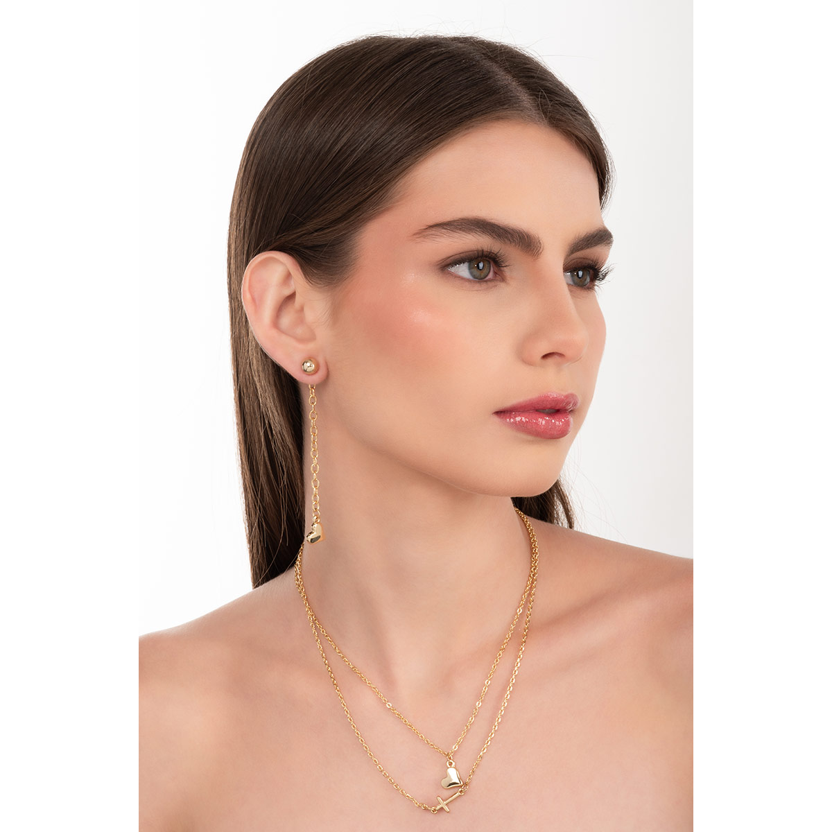 Arete en baño de oro con cadena y dije de corazón pulido, una propuesta moderna que suma movimiento y distinción a tu estilo diario.