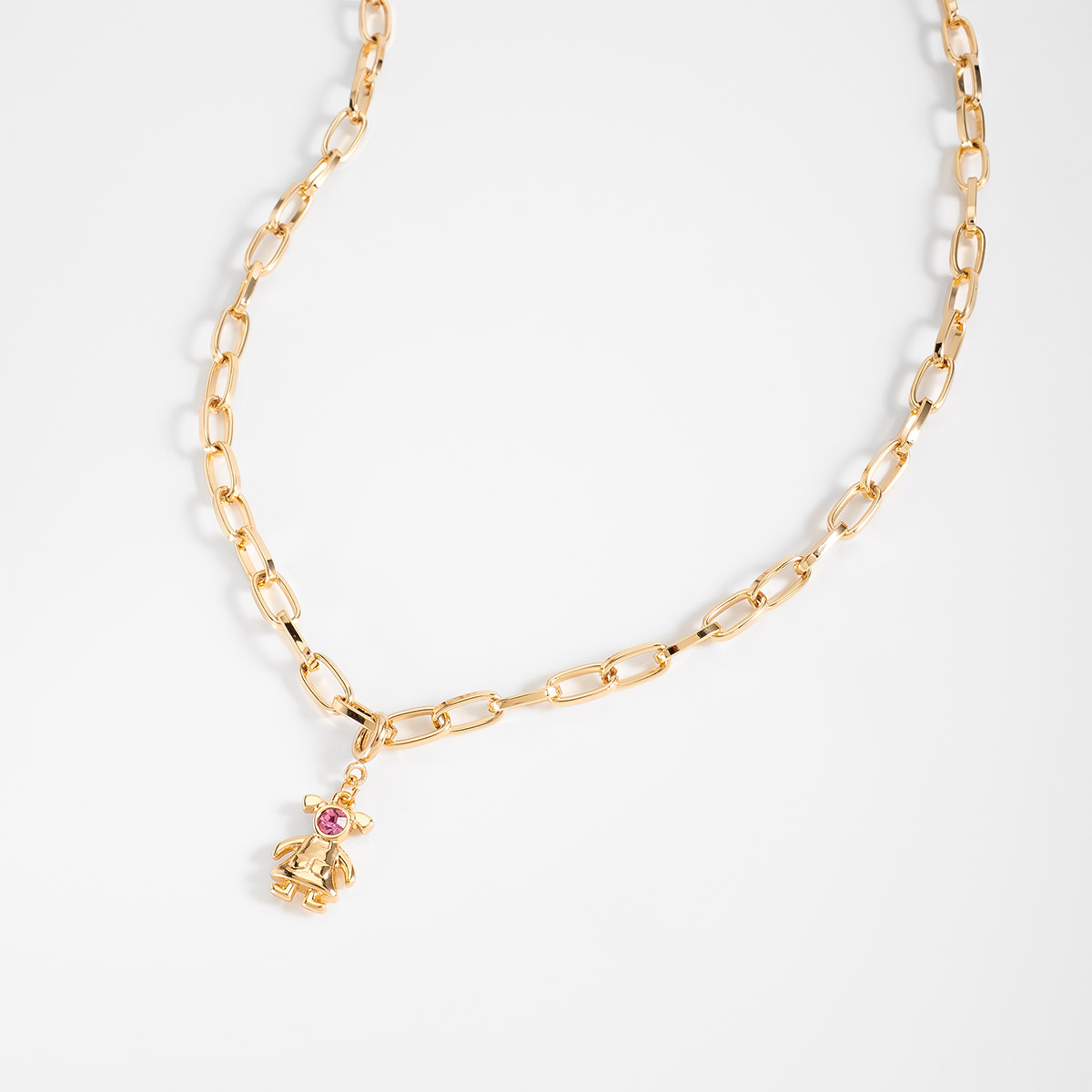 Dije en baño de oro figura niña con piedra rosa brillante