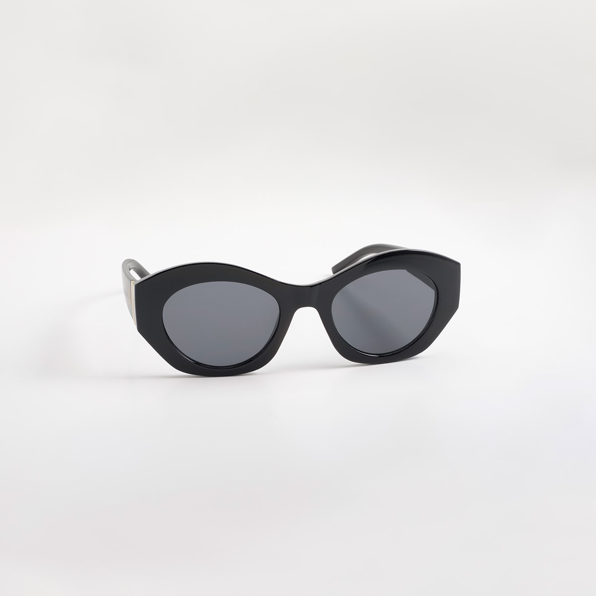 Lentes de sol negros con silueta cat eye y detalles dorados contemporáneos