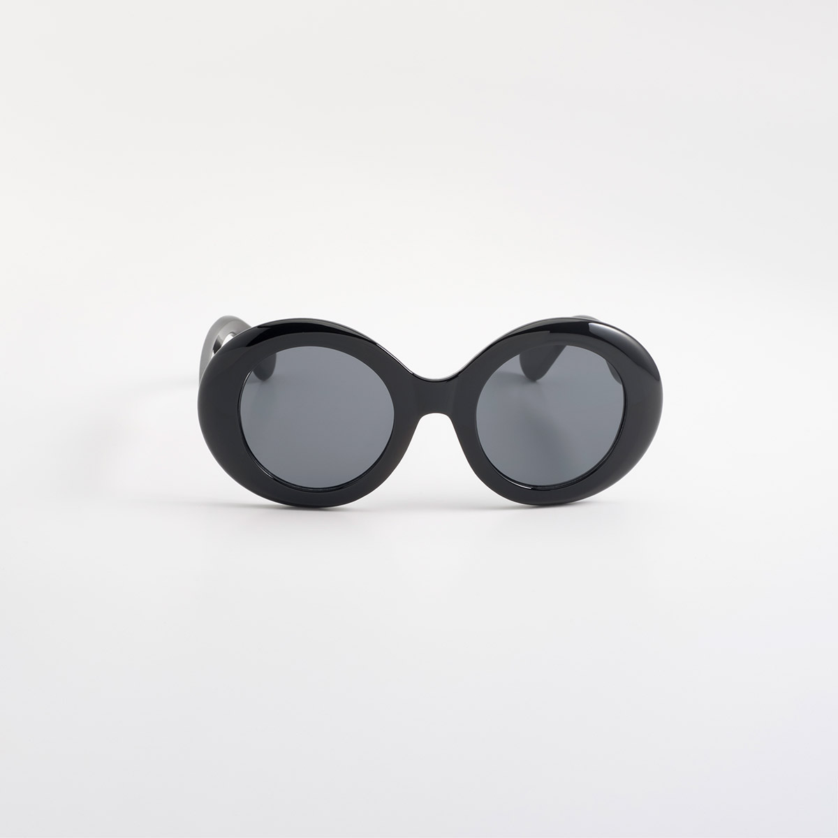 Lentes de sol negros con silueta redonda oversized y acabado brillante