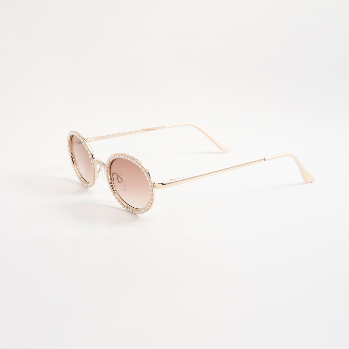 Lentes de sol dorados con silueta redonda y detalles tipo perla